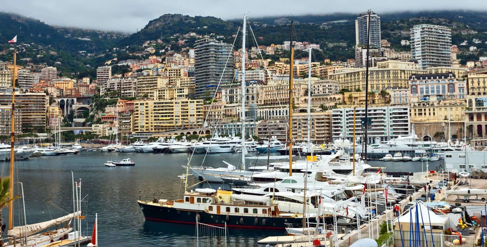 MONTE CARLO, MONACO - APRIL 28: Fashionable yachts in the port Hercules and view on the city on April 28, 2013 in Monte Carlo, Monaco. 

Monte Carlo, Monaco - April 28, 2013: Fashionable yachts in the port Hercules and view on the city.