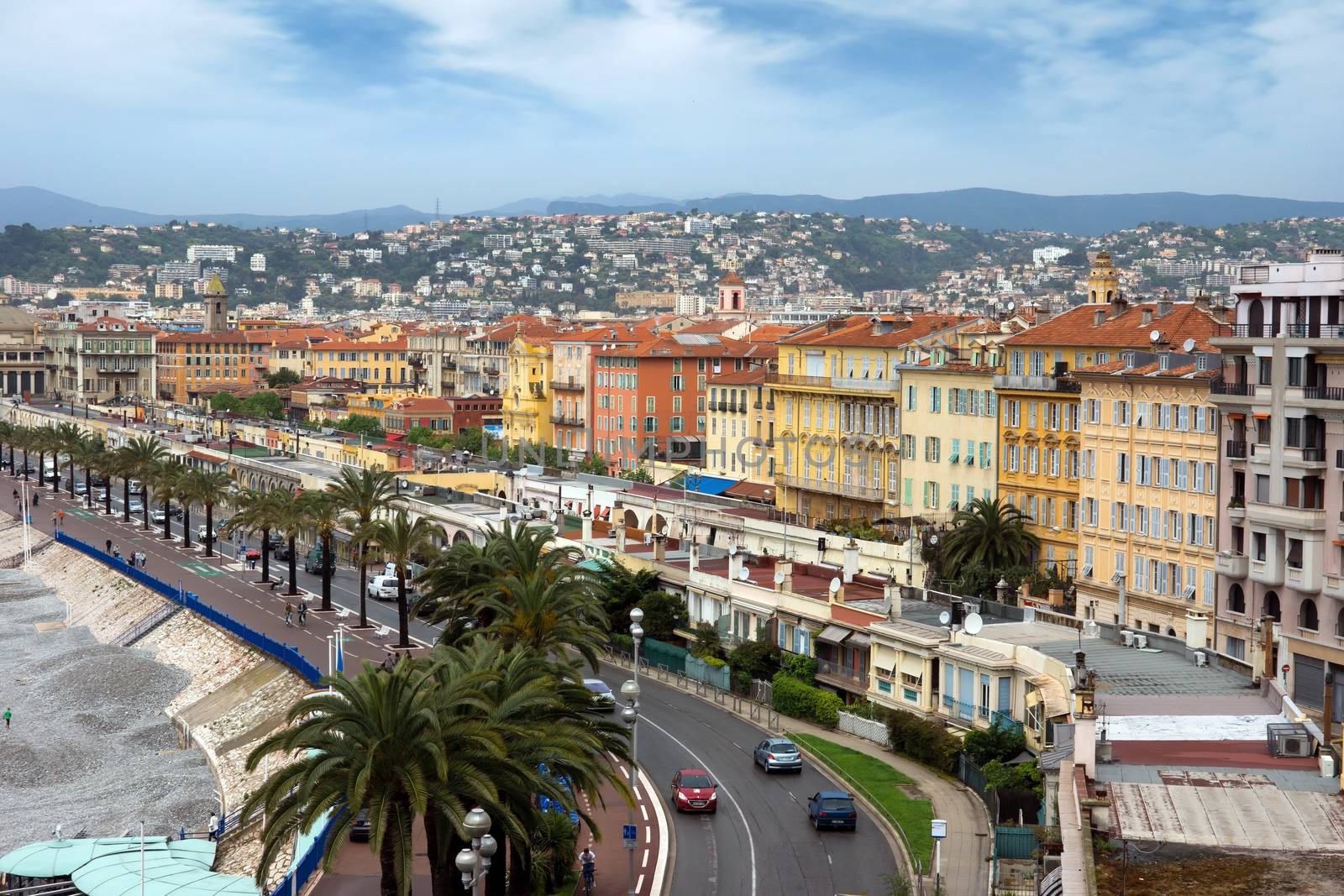 NICE, FRANCE - APRIL 29: Architecture along Promenade des Anglais on April 29, 2013 in Nice, France. It is a symbol of the Cote d'Azur and was built in 1830 at the expense of the British colony.

Nice, France - April 29, 2013: Architecture along Promenade des Anglais. People are resting. Promenade des Anglais is a symbol of the Cote d'Azur and was built in 1830 at the expense of the British colony.