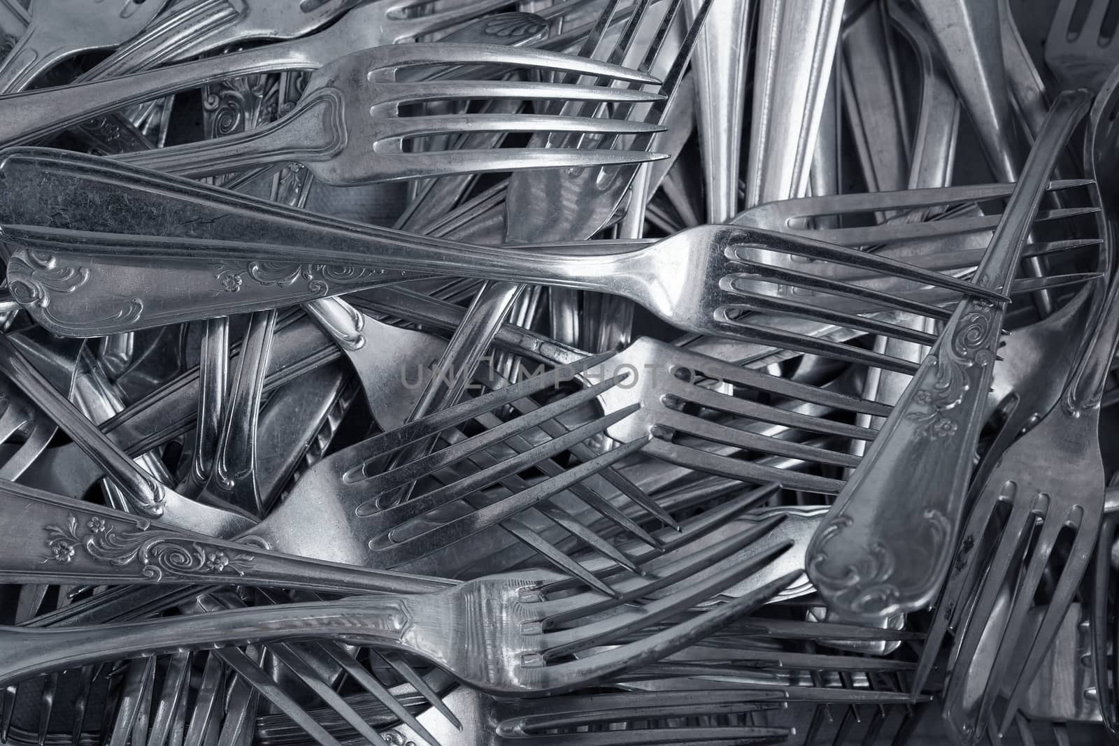 Background of heap old fashioned silver forks.