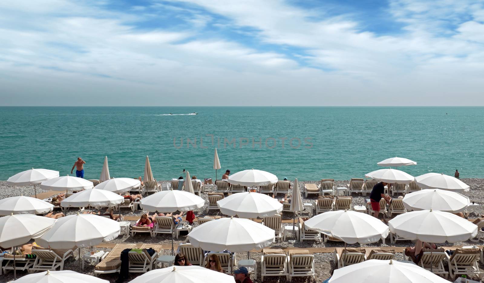 NICE, FRANCE - MAY 2: Beach with umbrellas near Promenade des Anglais on May 2, 2013 in Nice, France. People are sunbathing on spring hot day.

Nice, France - May 2, 2013: Beach with umbrellas near Promenade des Anglais. People are sunbathing on spring hot day.