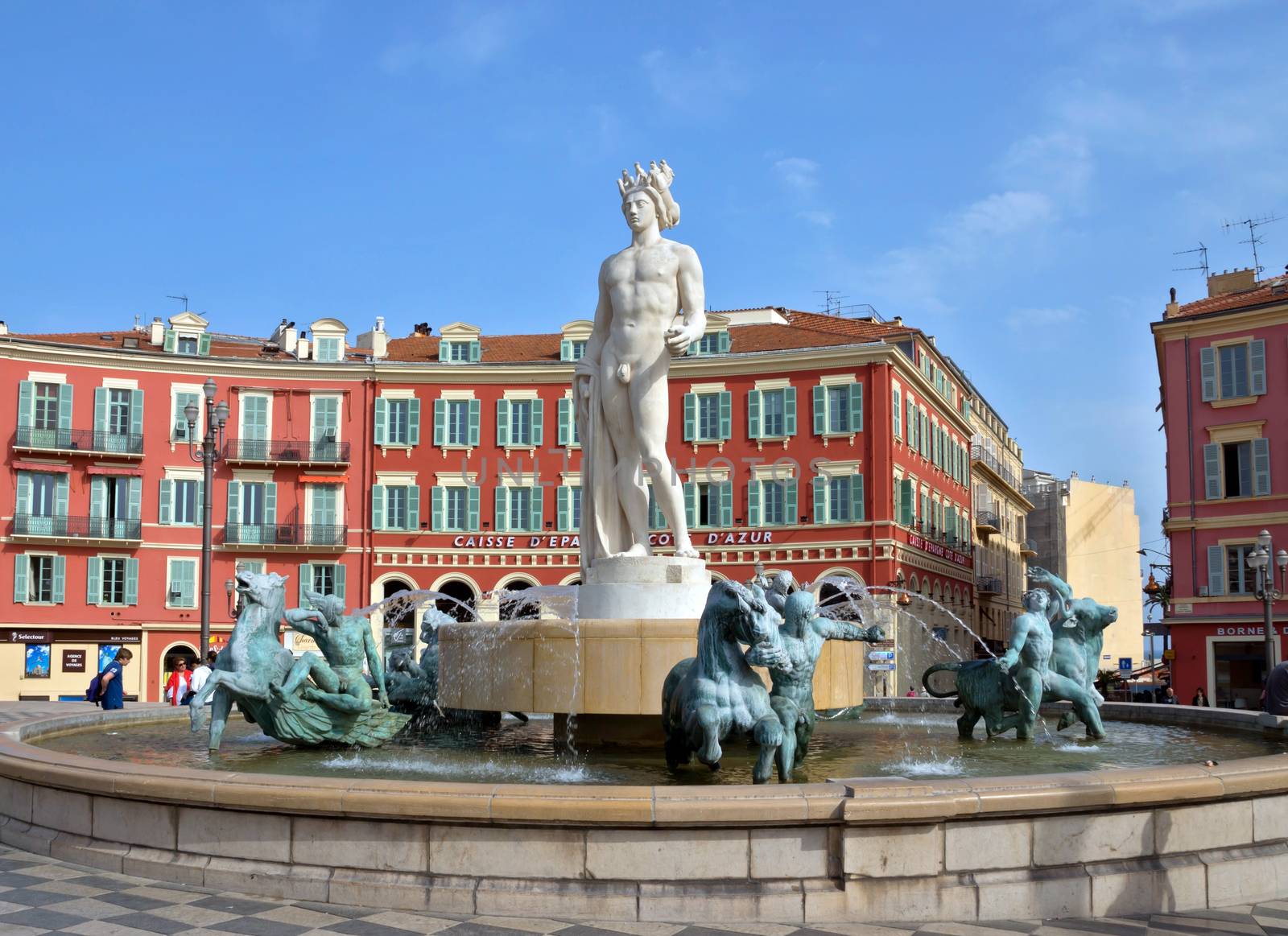 NICE, FRANCE - MAY 2:  Fountain Soleil on Place Massena on May 2, 2013 in Nice, France. The square was reconstructed in 1979.

Nice, France - May 2, 2013: Fountain Soleil on Place Massena. Square is located in the city center and is the most popular destination among tourists. The square was reconstructed in 1979. People are resting near the fountain.