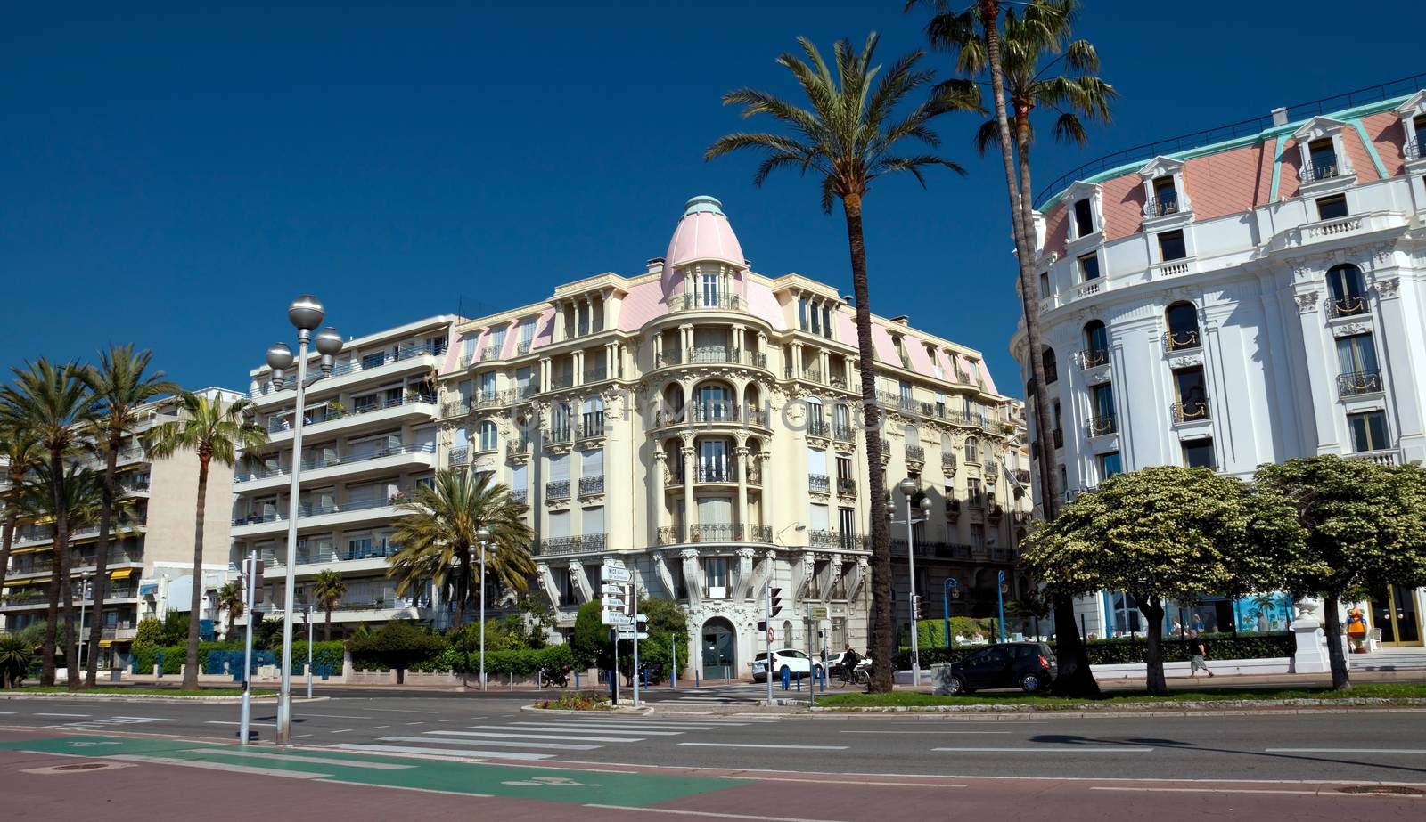 NICE, FRANCE - MAY 4: Architecture along Promenade des Anglais on May, 4, 2013 in Nice, France. It is a symbol of the Cote d'Azur and was built in 1830 at the expense of the British colony.

Nice, France - May 4, 2013: Architecture along Promenade des Anglais. People are walking. Promenade des Anglais is a symbol of the Cote d'Azur and was built in 1830 at the expense of the British colony.