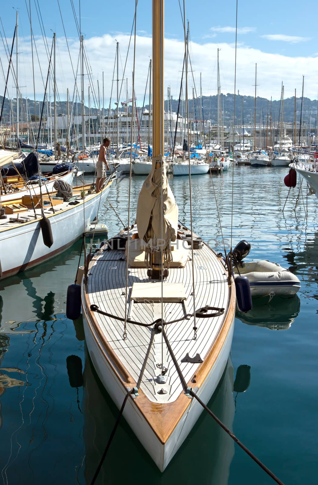 CANNES, FRANCE - MAY 6: Sailing boats moored in the port on May 6, 2013 in Cannes, France.

Cannes, France - May 6, 2013: Sailing boats moored in the port of Cannes. A man stands on a yacht and looks into the distance.