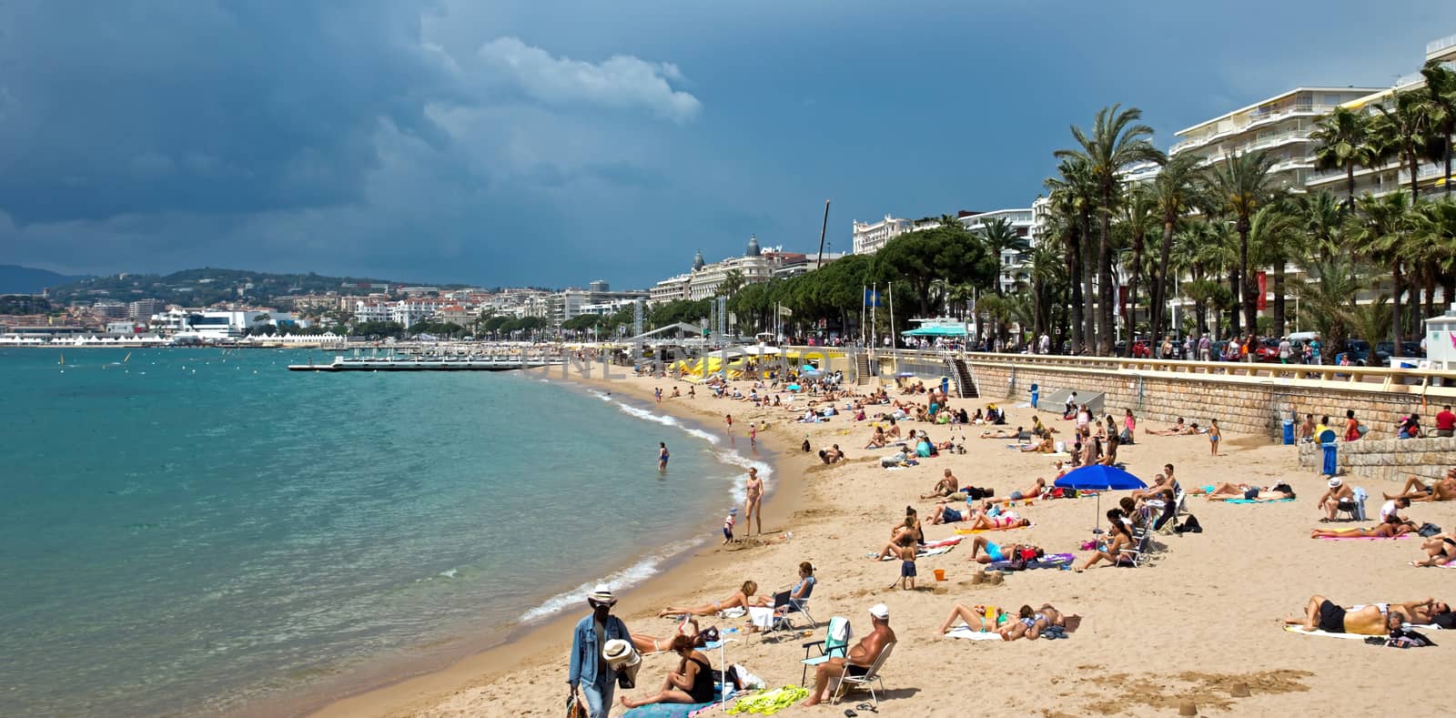 CANNES, FRANCE - MAY 6: People on the most popular beach - Plage de la Croisette on May 6, 2013 in Cannes, France. The famous beach on the Croisette, known for its filmfestival in may.

Cannes, France - May 6, 2013: People on the most popular beach in Cannes - Plage de la Croisette. The famous beach on the Croisette, known for its filmfestival in may. People are sun bathing, swiming and resting