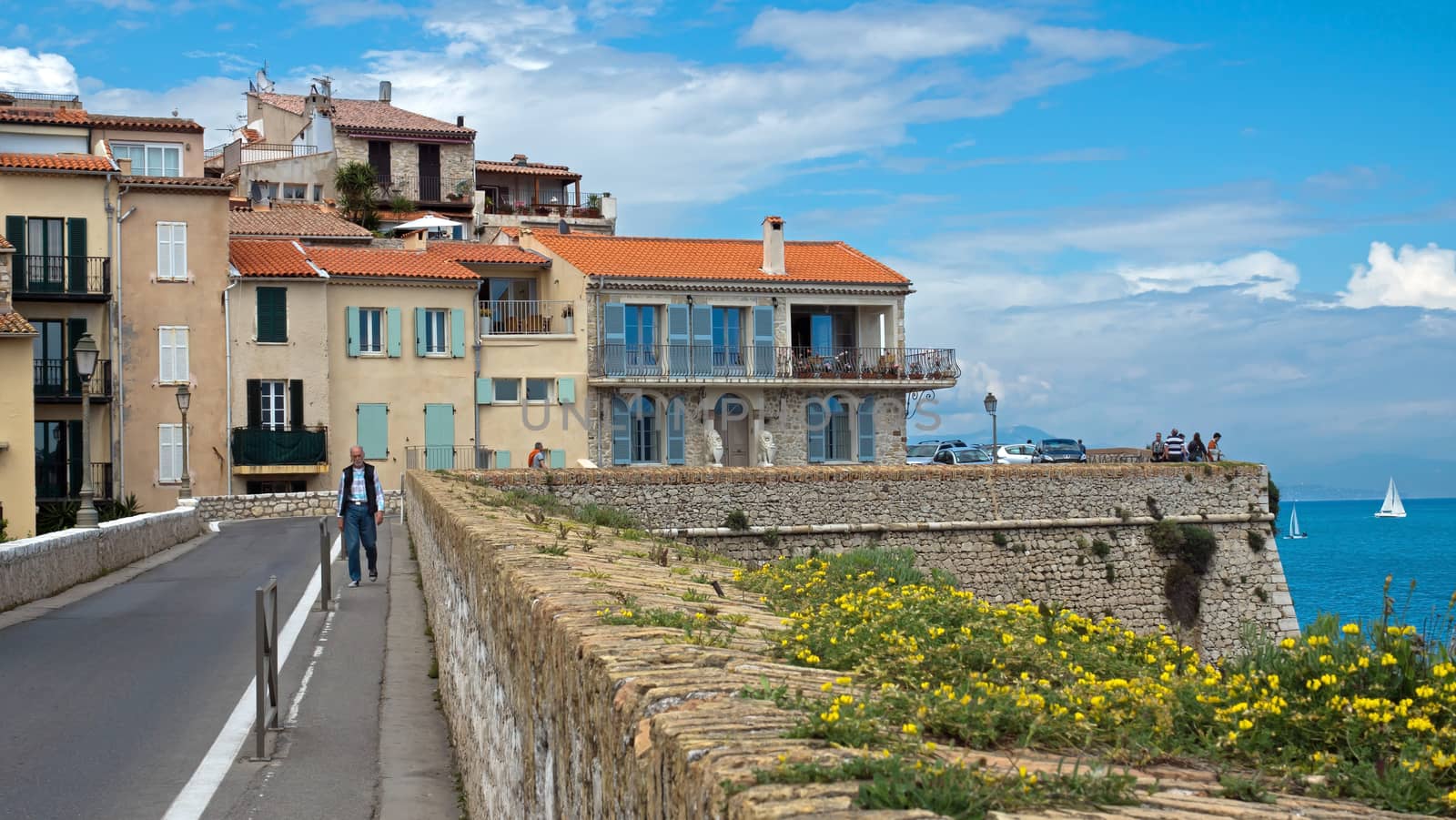ANTIBES, FRANCE - MAY 6: Cityscape and mediterranean coast on May 6, 2013 in Antibes, France. 

Antibes, France - May 6, 2013: Cityscape and mediterranean coast. Man walks along street.