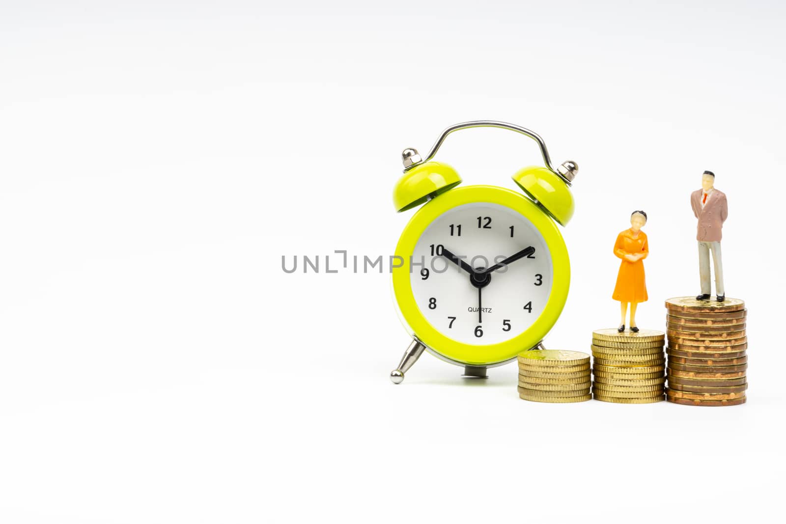 Kuala Lumpur, Malaysia - March 2, 2019 : Alarm Clock and Miniature people standing on stacking coins with white background. Business and Lifestyle concepts.