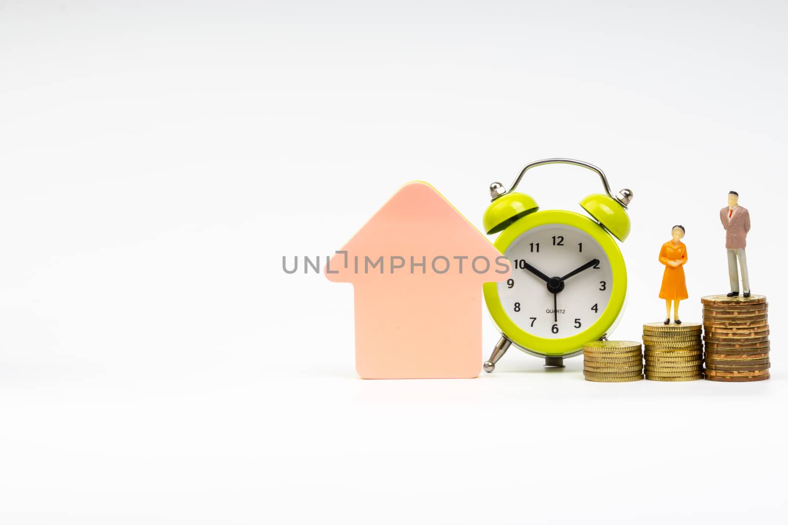 Kuala Lumpur, Malaysia - March 2, 2019 : Alarm Clock and Miniature people standing on stacking coins with white background. Business and Lifestyle concepts.