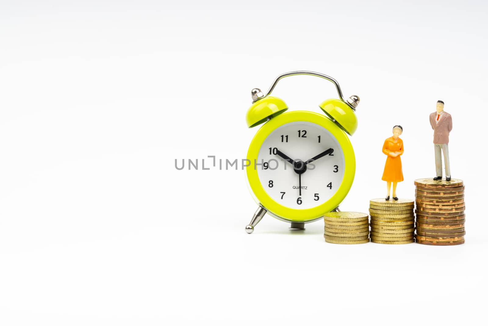 Kuala Lumpur, Malaysia - March 2, 2019 : Alarm Clock and Miniature people standing on stacking coins with white background. Business and Lifestyle concepts.