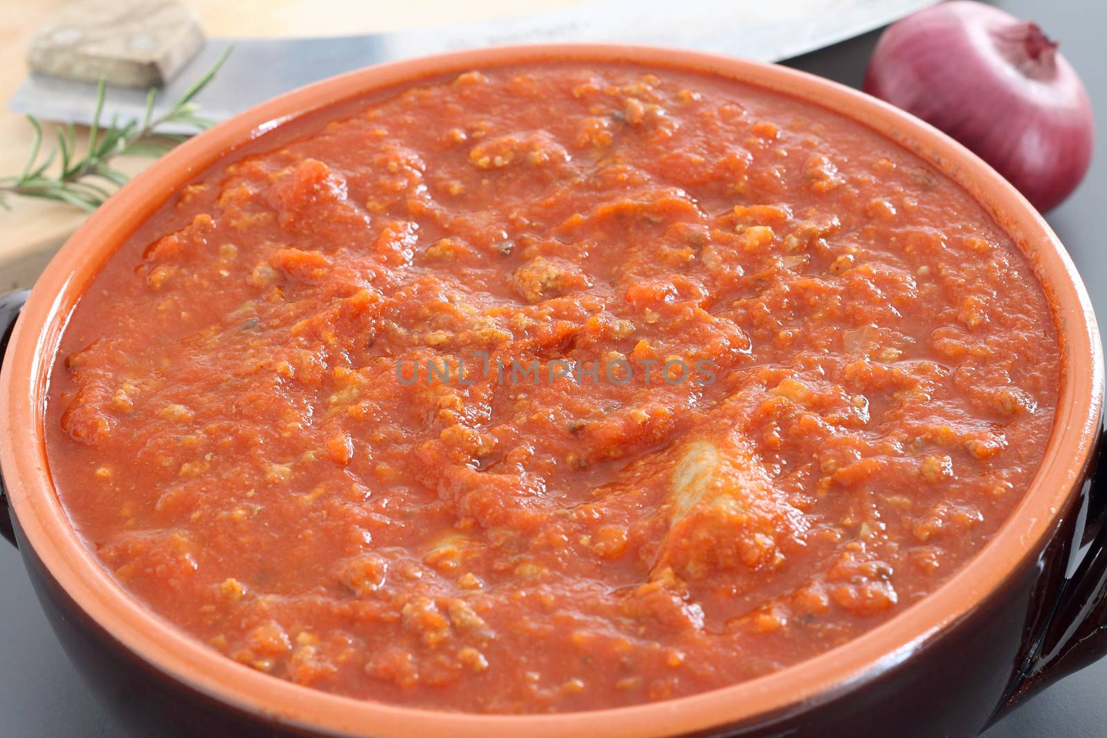 Bolognese sauce with sausage in terracotta pan