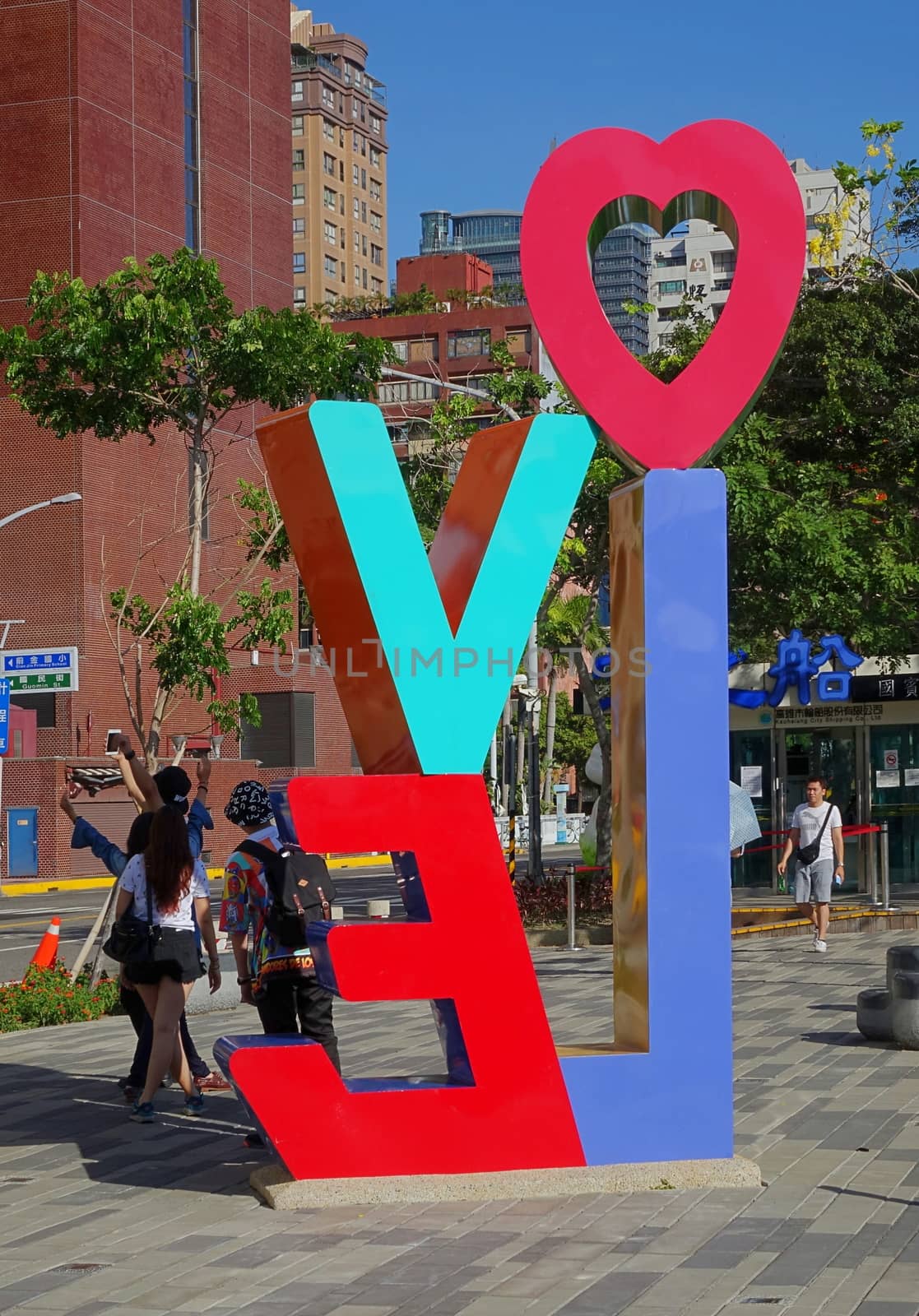 KAOHSIUNG, TAIWAN -- JUNE 14, 2015: Tourists take photos in front of a colorful Love sign on the banks of the Love River in Kaohsiung city.
