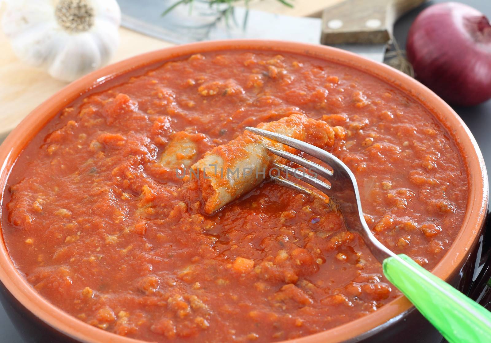 Bolognese sauce with sausage in terracotta pan