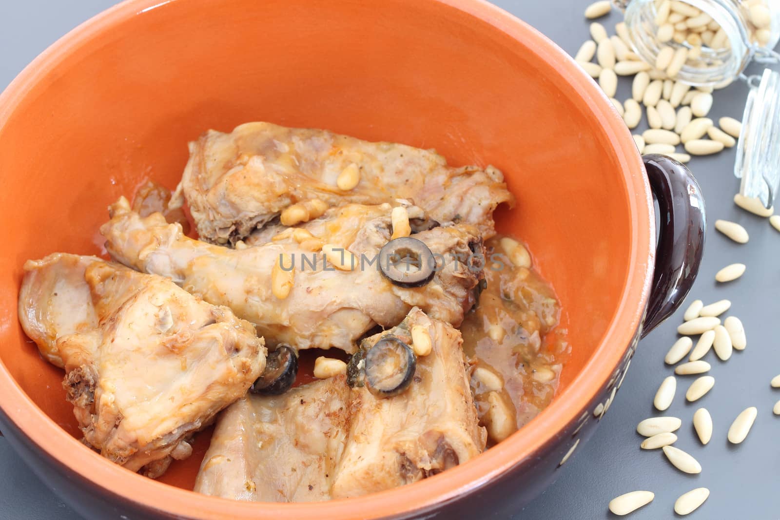 Rabbit meat with olives and pine nuts