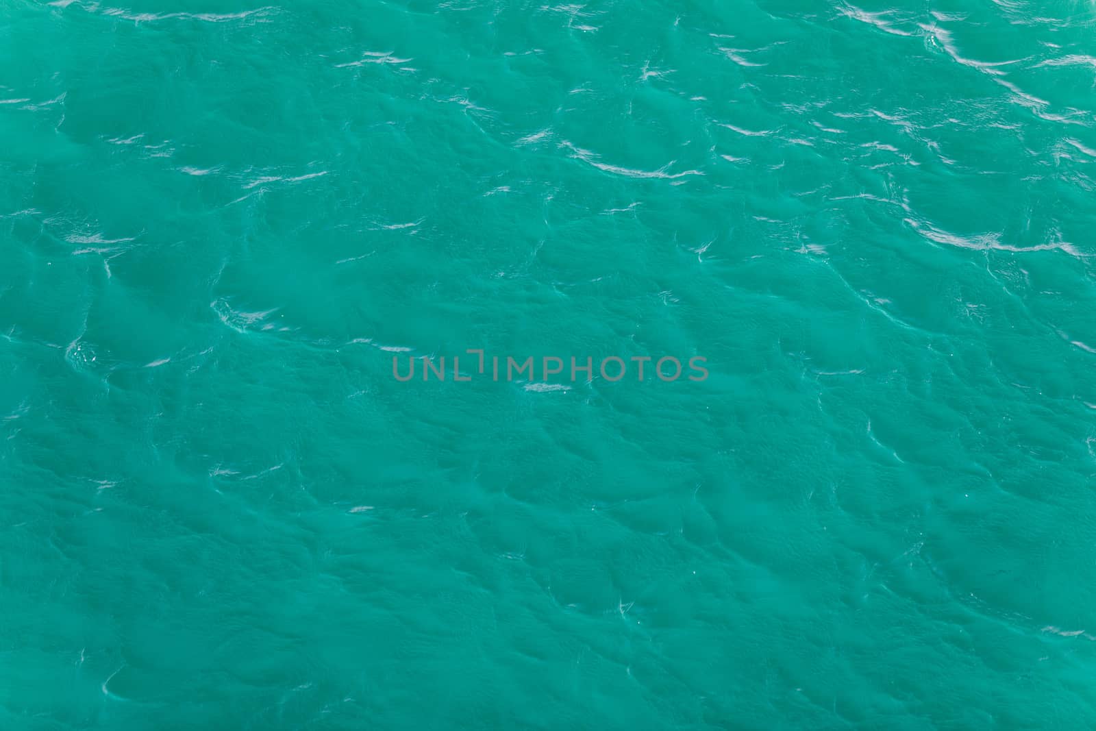 Background shot of aqua sea water surface. Sea surface aerial view. Waving water surface of the sea background.