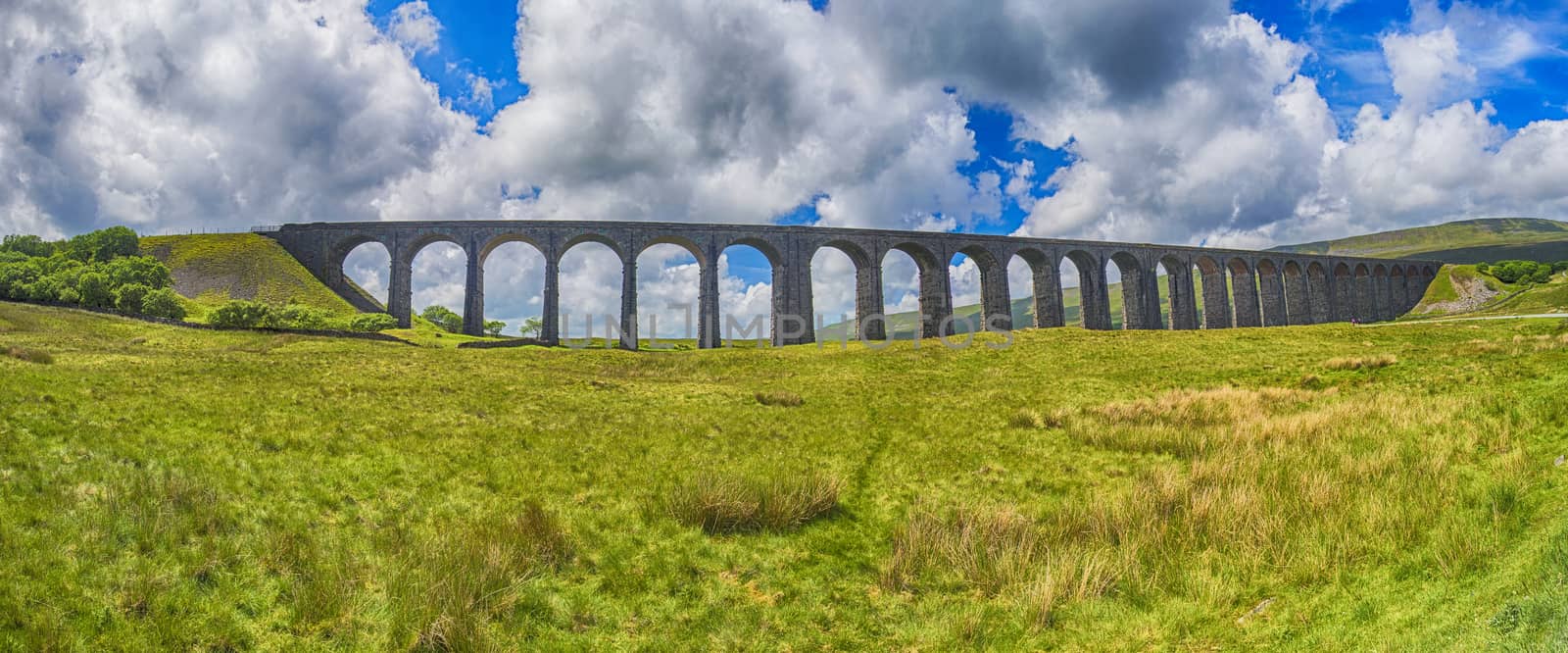 View of a large old Victorian railway viaduct across valley in rural countryside scenery panorama 