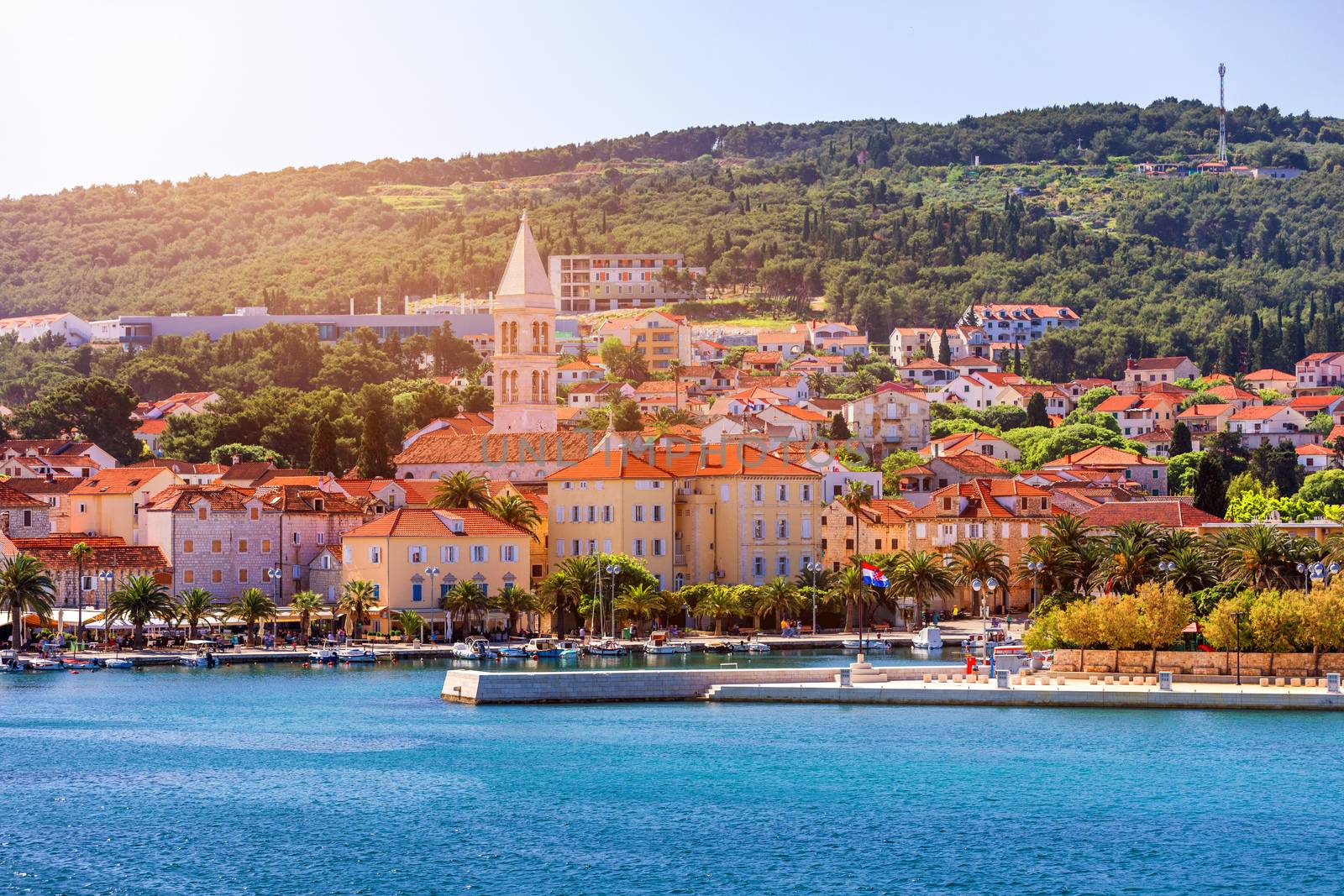 Supetar city in Brac island, Croatia. View from the sea. Picturesque scenic view on Supetar on Brac island, Croatia. Panoramic view on harbor of town Supetar from the side of sea. Brac, Croatia.