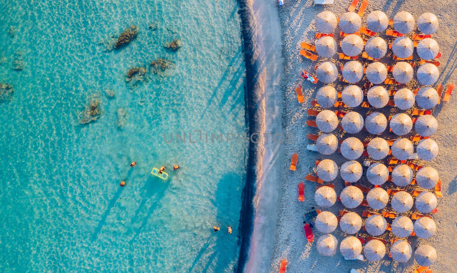Aerial view of beautiful tropical Elafonissi Beach with pink sand. View of a nice tropical beach from the air. Beautiful sky, sea, resort. Seascape: Ocean and beautiful beach paradise. Elafonissi beach, Crete, Greece.