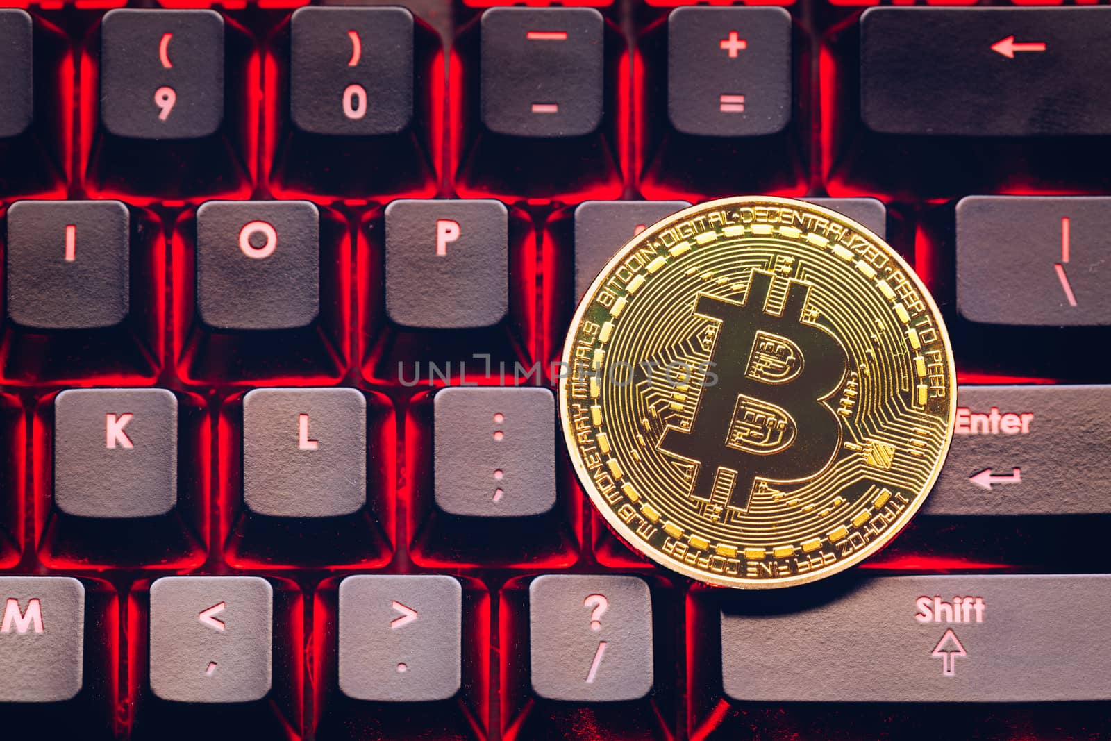 Bitcoin on compuer keyboard in background, symbol of electronic virtual money and mining cryptocurrency concept. Coin crypto currency bitcoin lies on the keyboard. Bitcoin on keyboard.