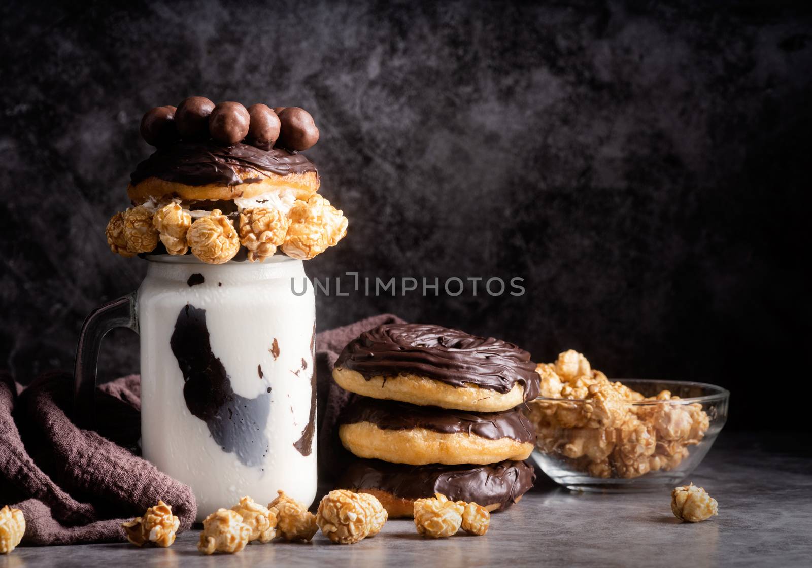 Chocolate donut milkshake decorated with popcorn, whipped cream and candies by Desperada