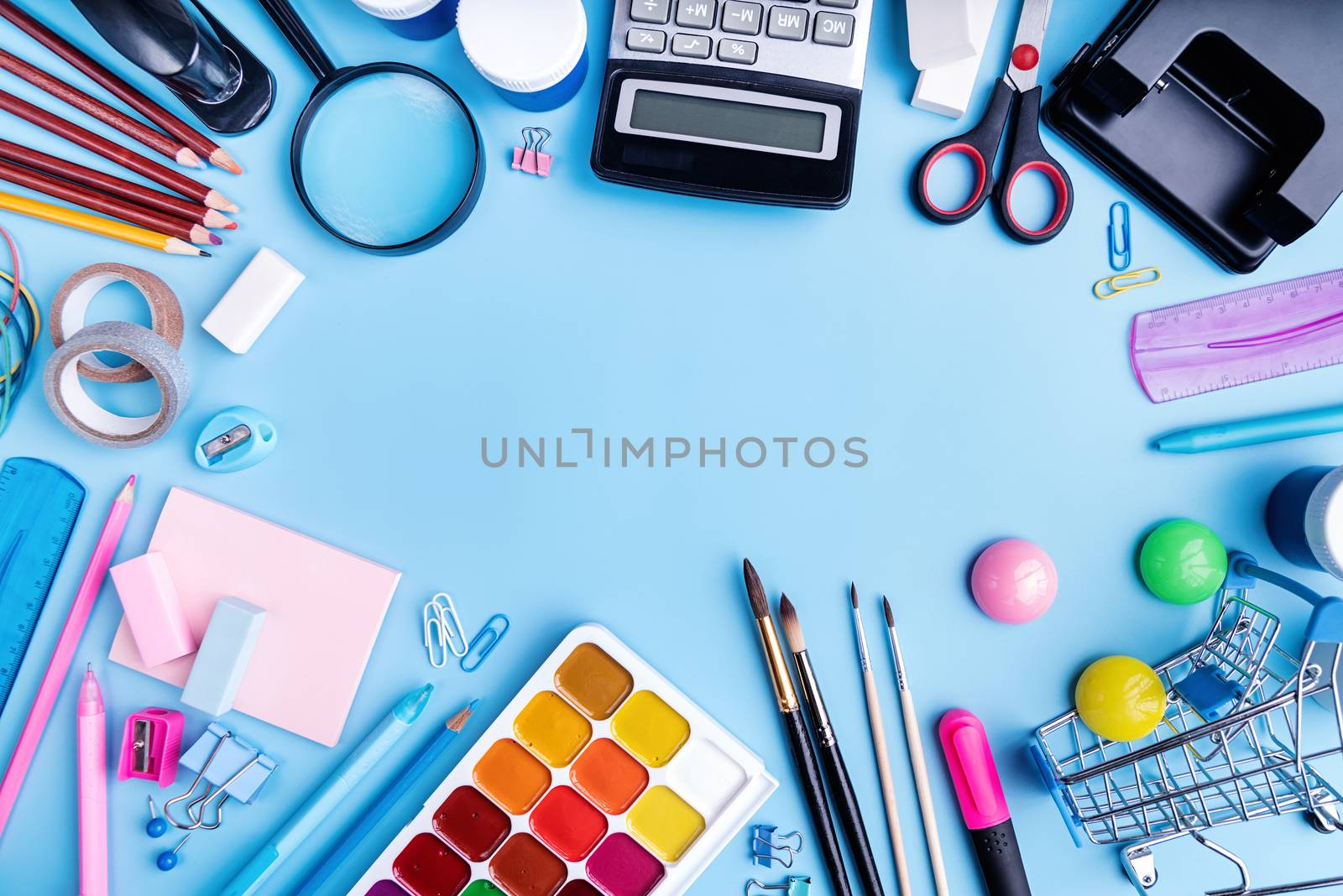 Back to school concept. School and office supplies on blue table. Flat lay with copy space.