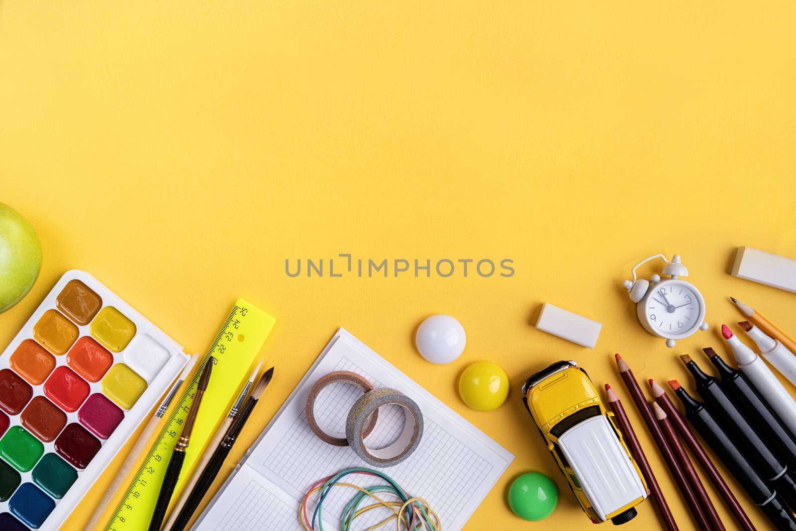 Back to school concept. School and office supplies on yellow background. Flat lay with copy space.