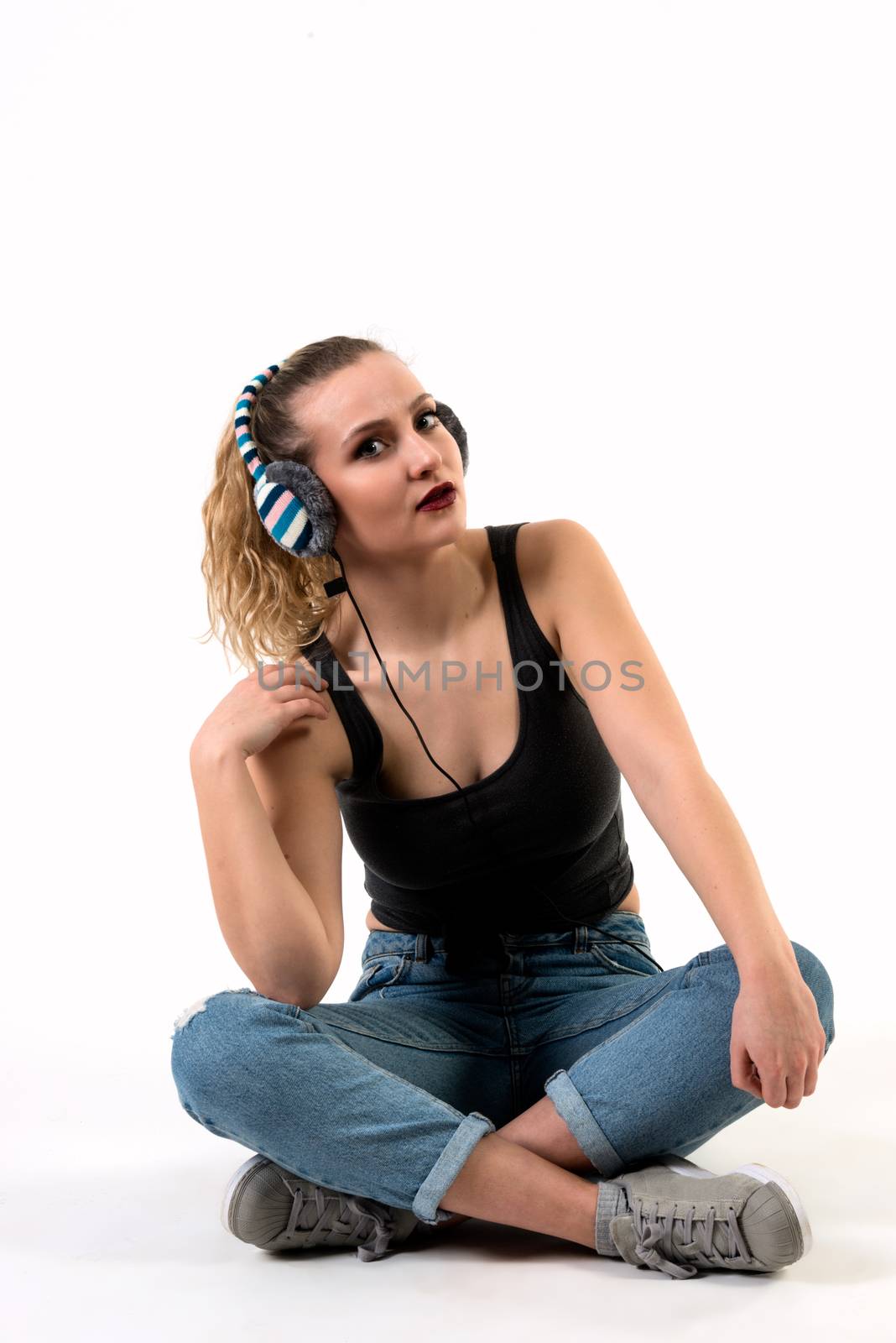 Young Woman Sitting Cross-legged Listening on Headphones