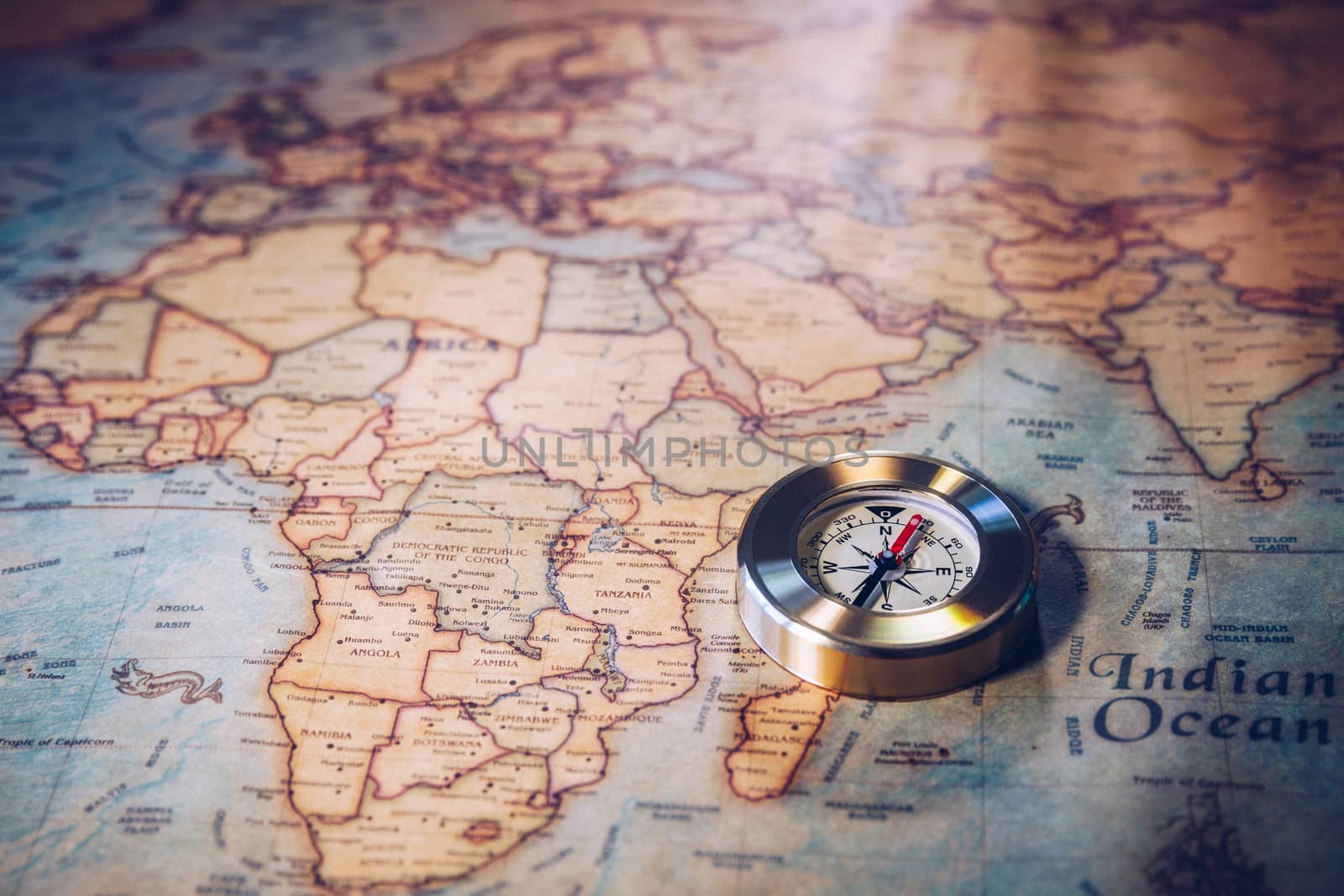 Old vintage retro golden compass on ancient map. Selective focus, shallow depth of field. Concept of world travel, sightseeing and tourism.