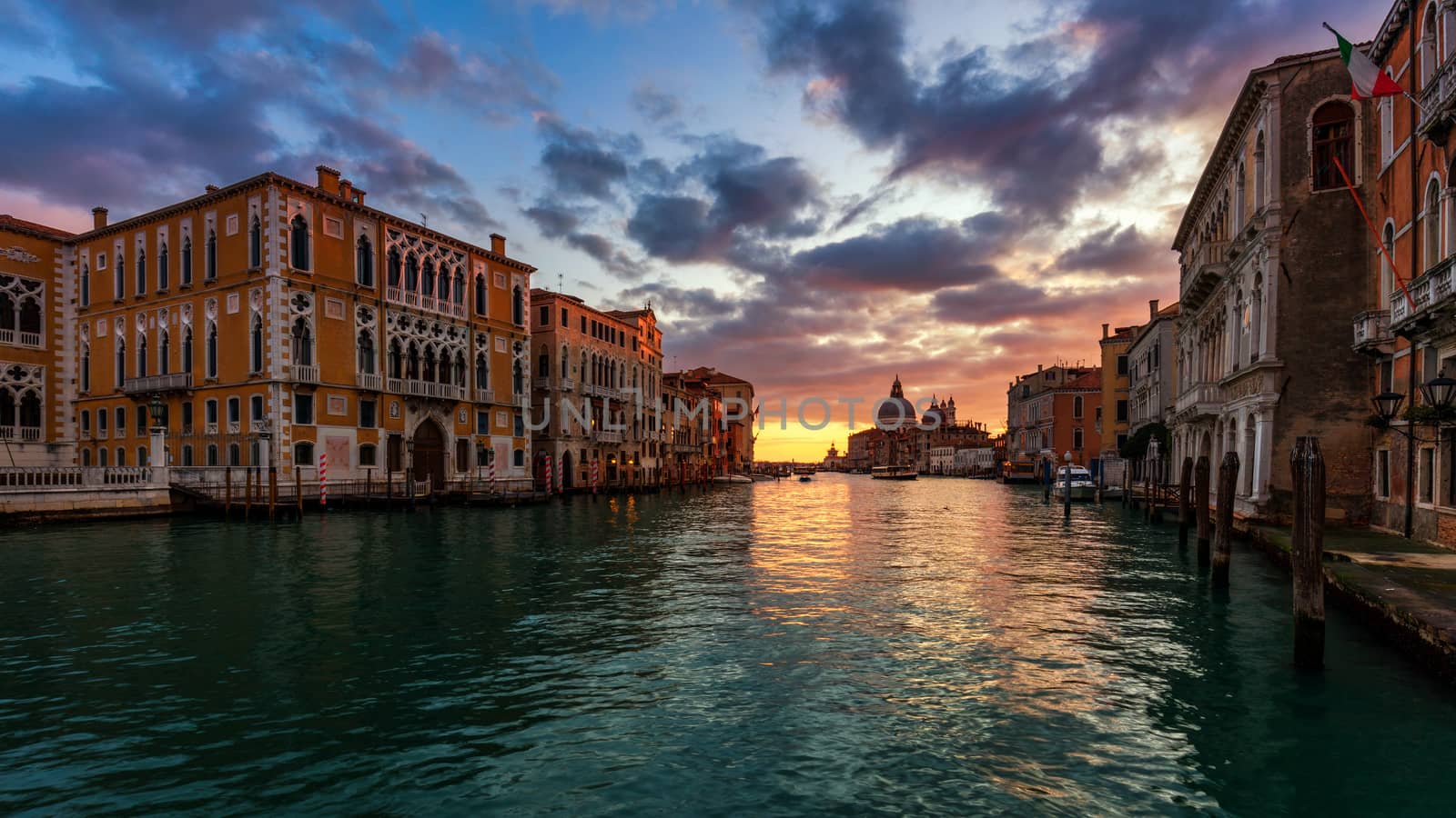 View of the street canal in Venice, Italy. Colorful facades of old Venice houses. Venice is a popular tourist destination of Europe. Venice, Italy.
