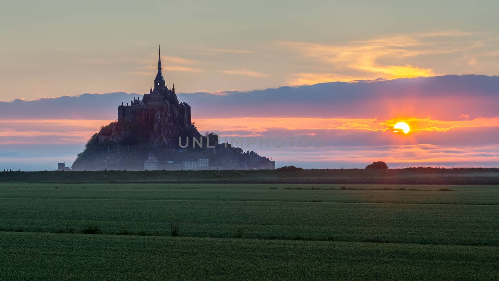 Beautiful panoramic view of famous Le Mont Saint-Michel tidal island at sunrise. Normandy, northern France