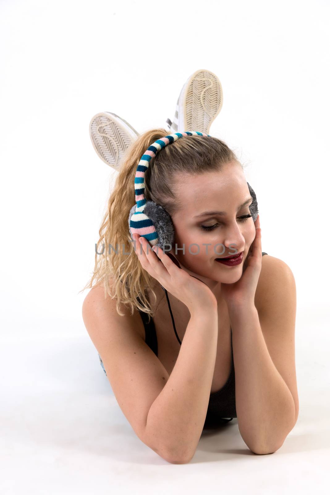 Young Woman Listening on Headphones Lying down