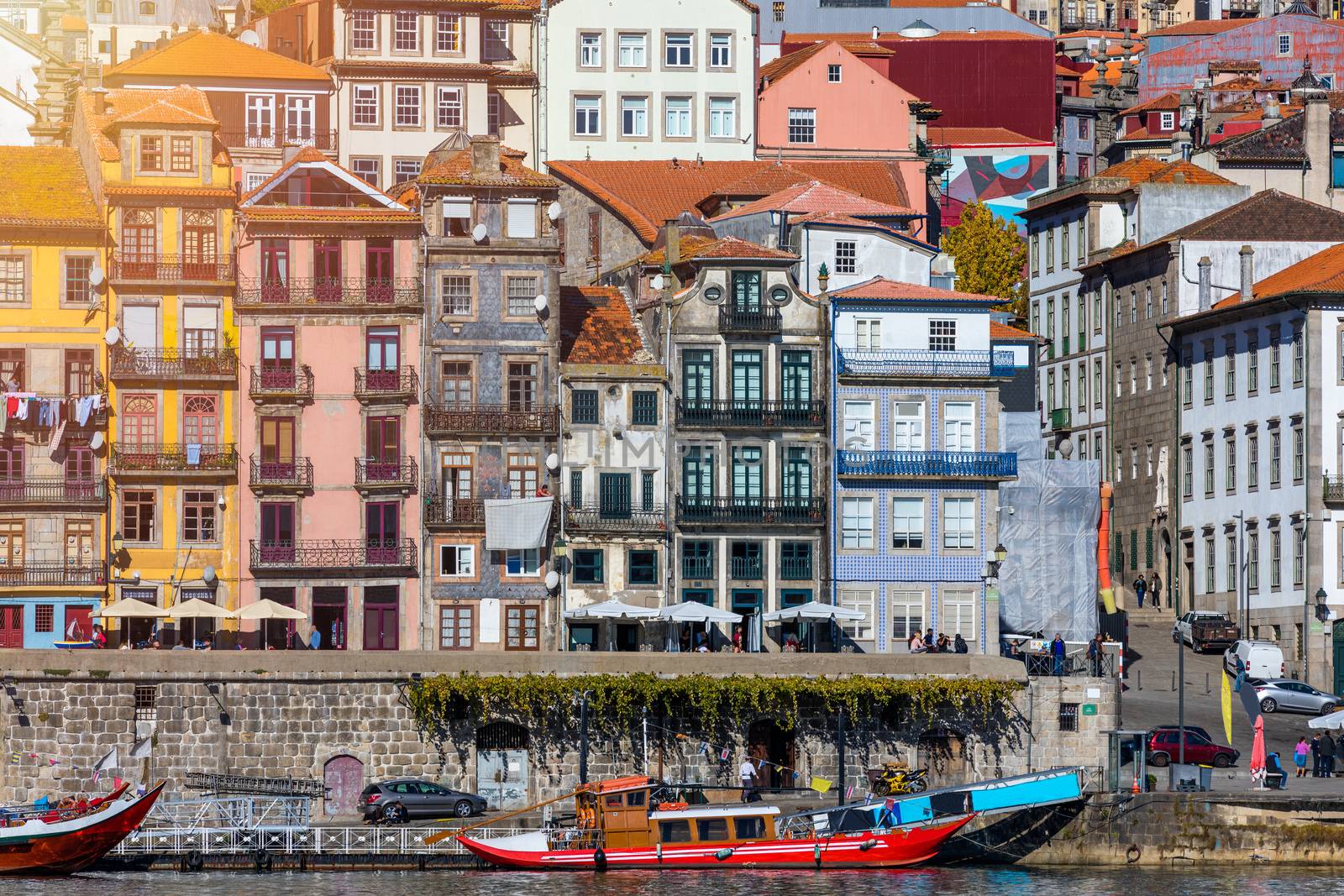 Colorful houses of Porto Ribeira, traditional facades, old multi-colored houses with red roof tiles on the embankment in the city of Porto, Portugal