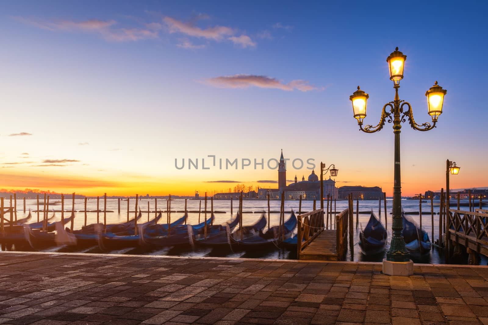 Venice with famous gondolas at sunrise, Italy. Gondolas in lagoon of Venice on sunrise, Italy. Venice with gondolas on Grand Canal against San Giorgio Maggiore church.