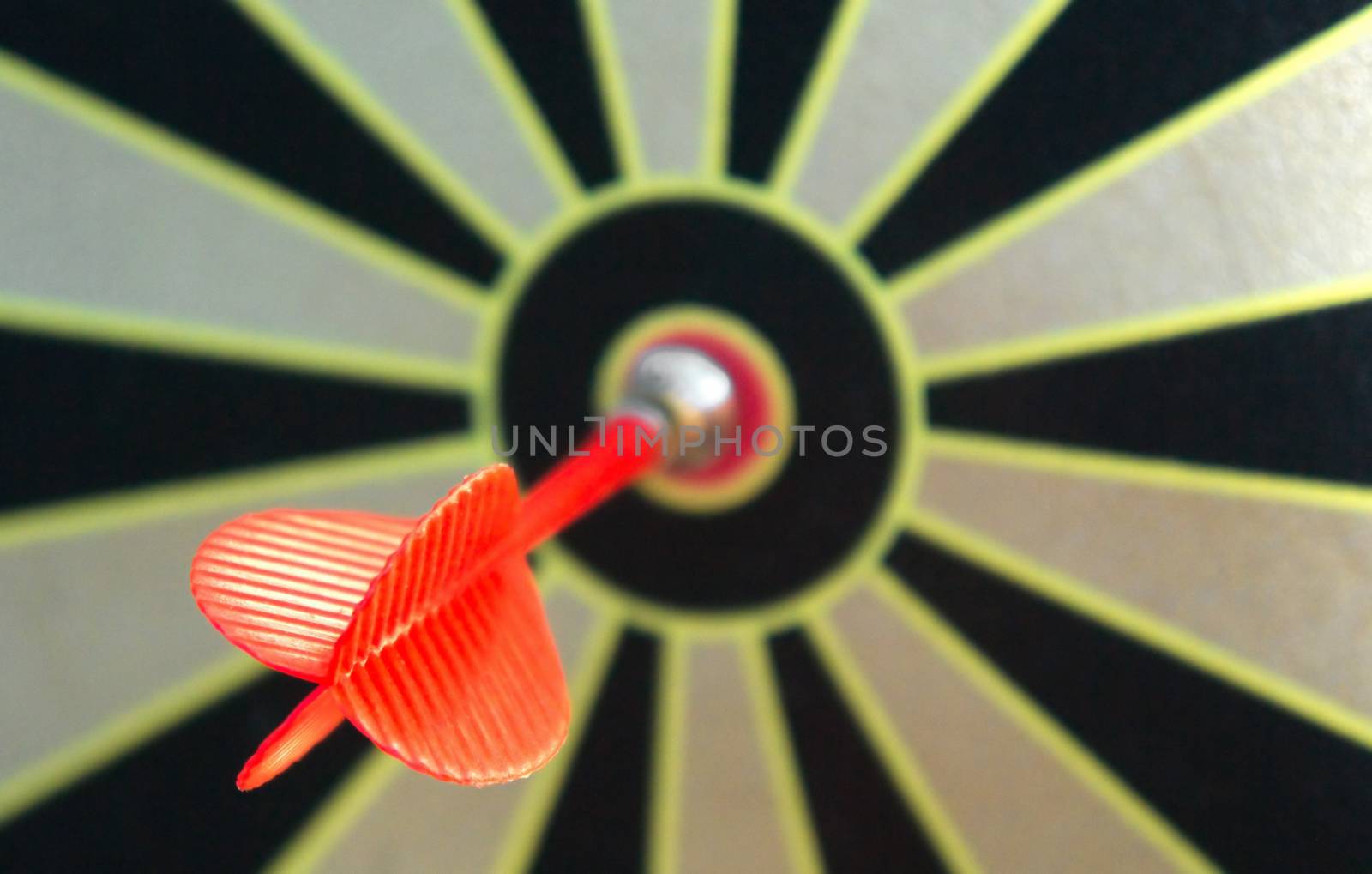 Red dart arrow in bulls eye in dart game board