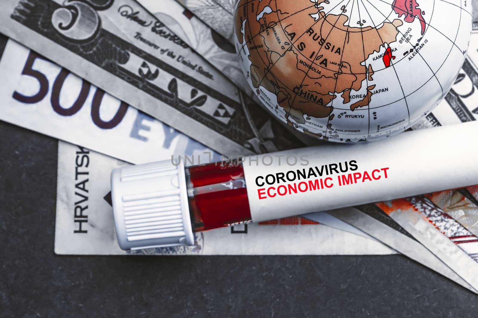 CORONAVIRUS ECONOMIC IMPACT text with currency banknotes, world globe and blood test vacuum tube on black background by silverwings