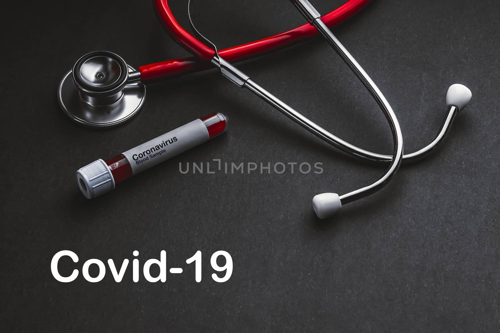 COVID-19  text with stethoscope and blood sample vacuum tube on black background by silverwings