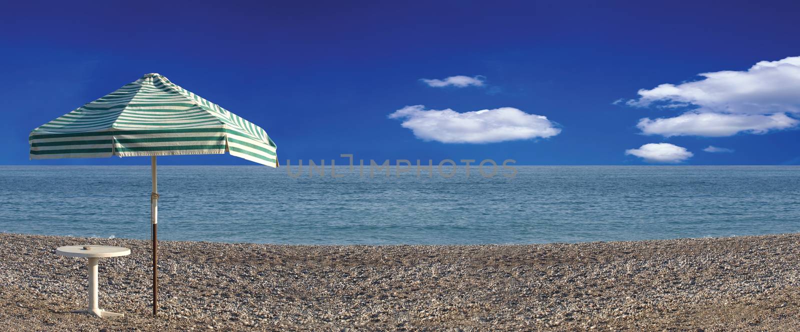 Panorama of striped beach umbrella on the beach