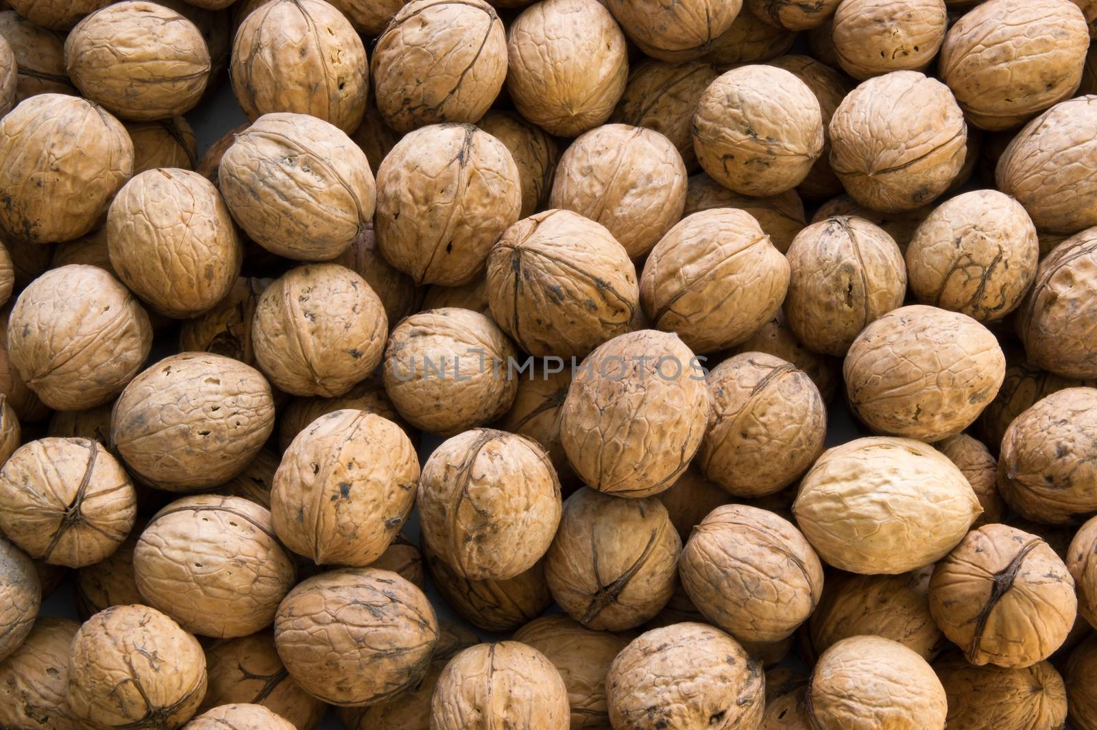Closeup of brown raw walnuts background