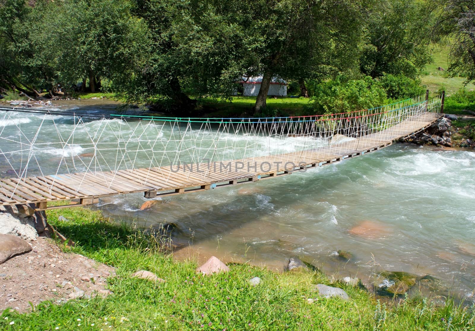 Home made suspension bridge over a mountain's river in the Kazakhstan.