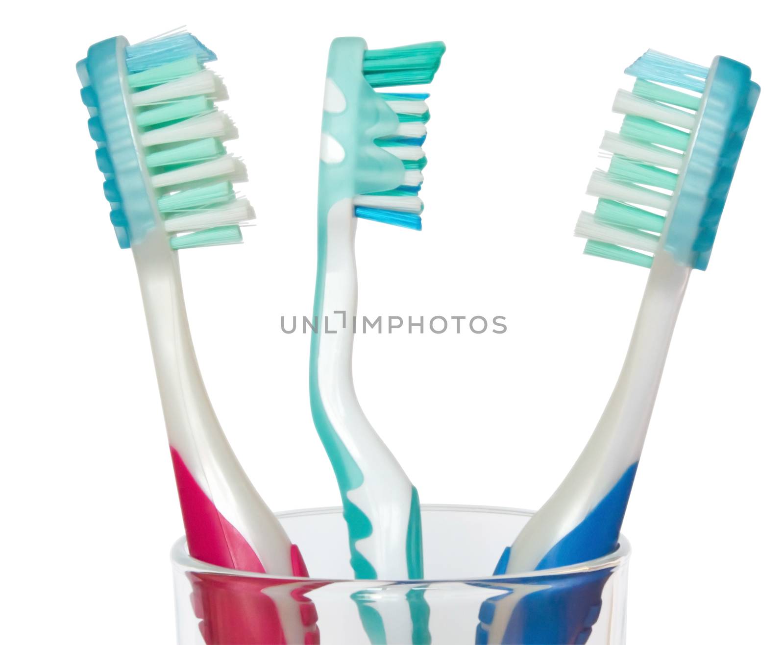 Three tooth brushes in glass. Isolated on white background. Clipping path.