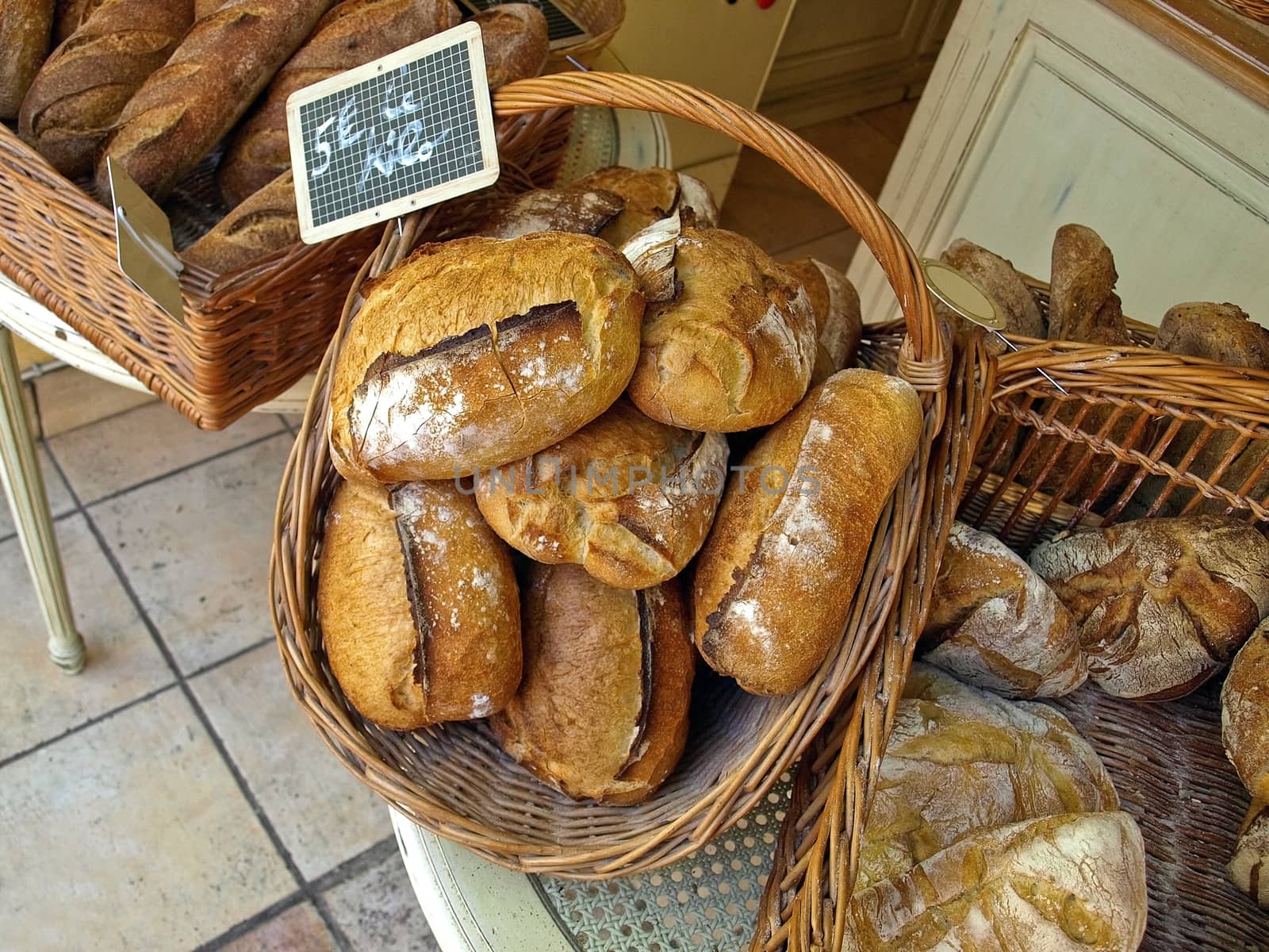 Various fresh crispy baked bread in basket.