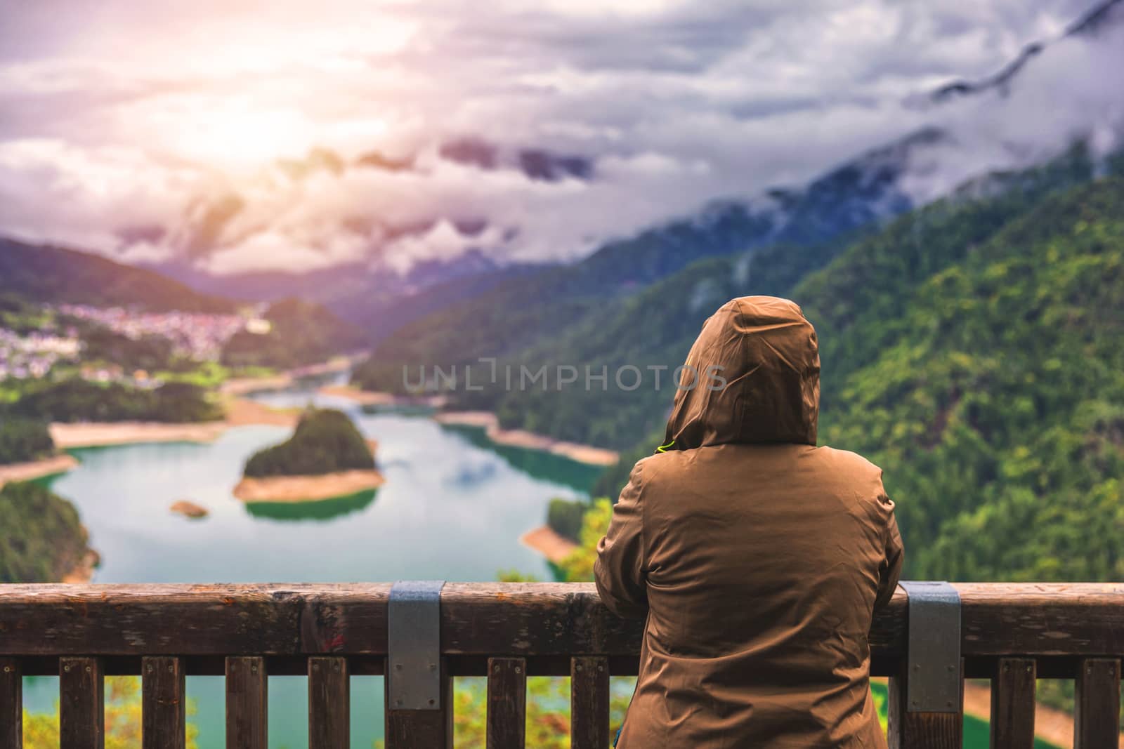 Traveler enjoying the panoramic view of lake of Centro Cadore in the Alps in Italy, Dolomites, near Belluno.