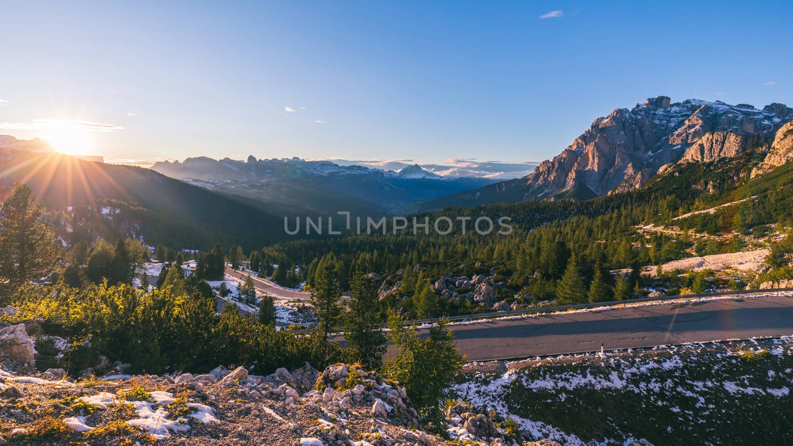 Dolomite Alps in Italy. Beautiful day. The road passes in the coniferous forests at the foot of limestone and dolomite rocks. The concept of active and car tourism