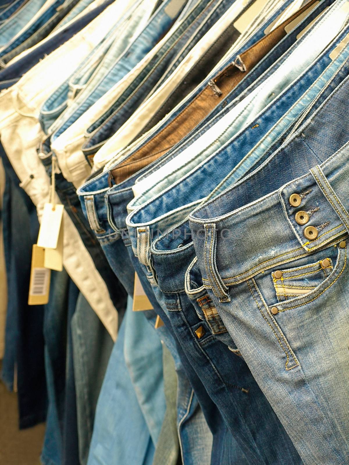Row of hanged blue jeans in a shop.