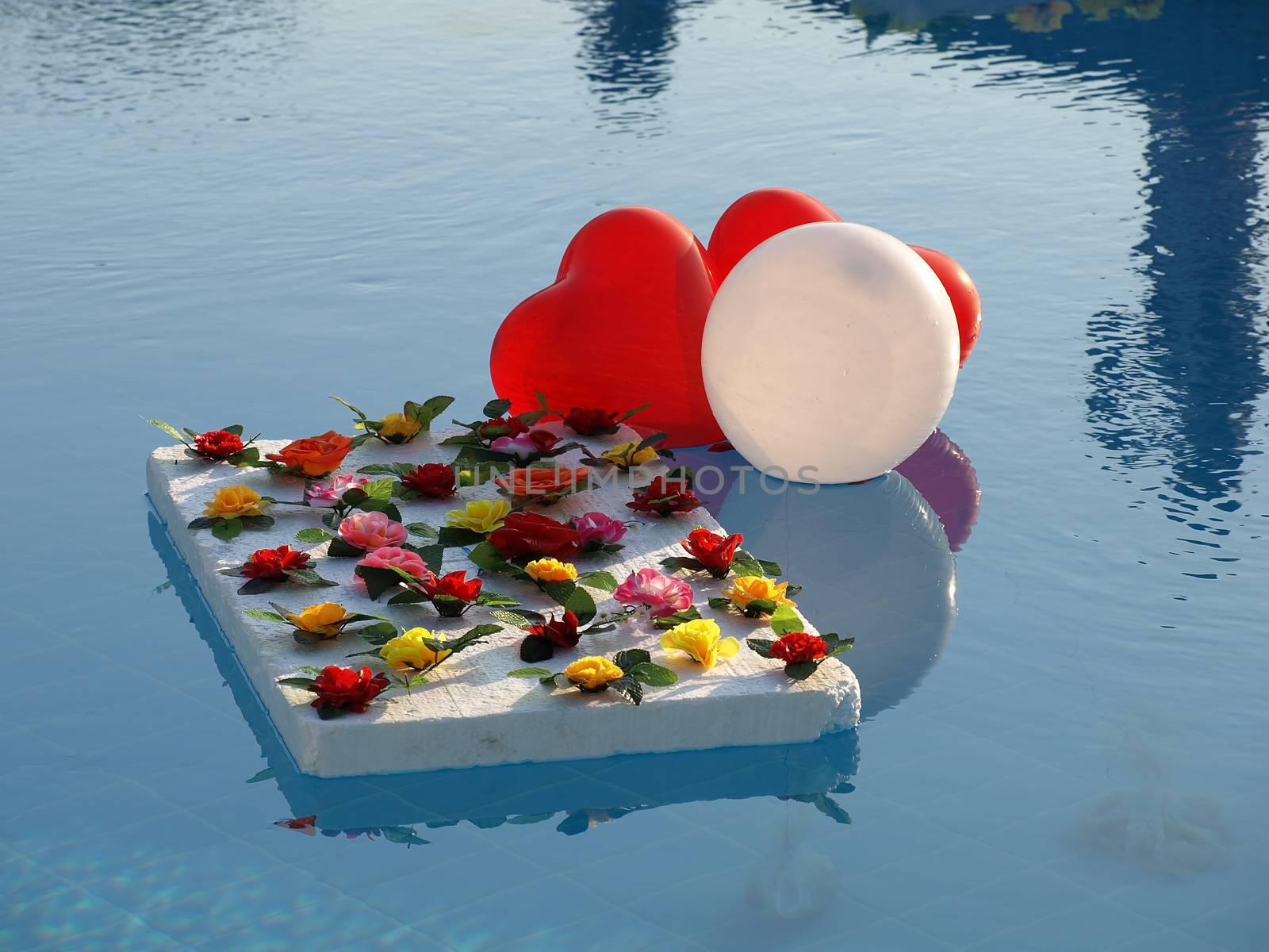 Abstract decoration of inflated heart-shaped balloons on a water.