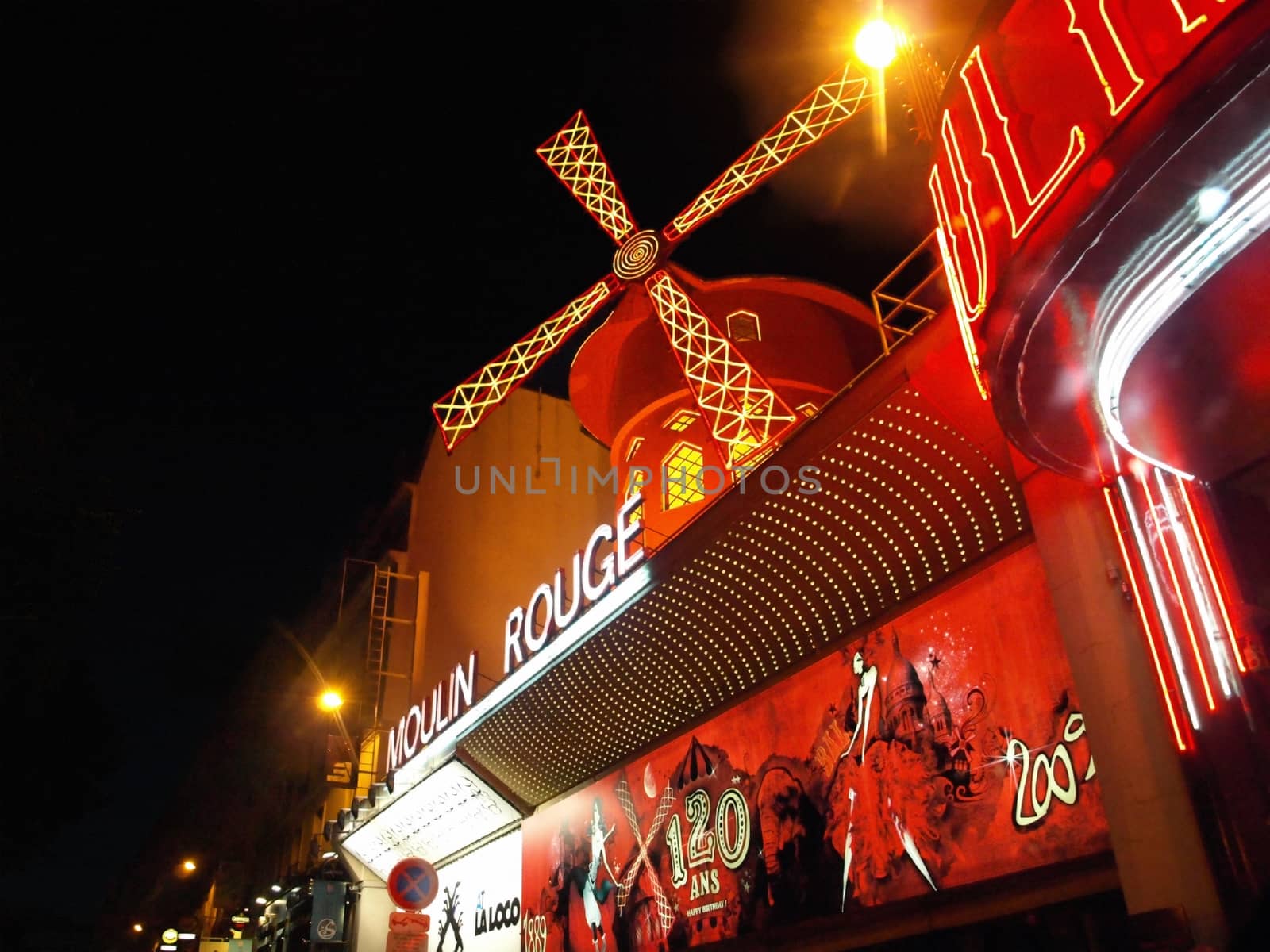 PARIS FRANCE - JULY 24: The Moulin Rouge by night July 24, 2009 in Paris, France. Moulin Rouge is a famous cabaret built in 1889, locating in the Paris red-light district of Pigalle