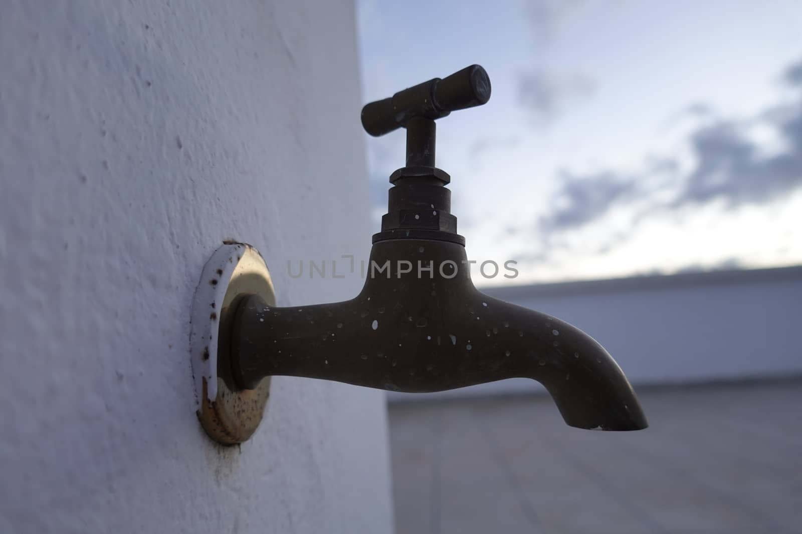 moroccan old faucet with a rustic color and white background.