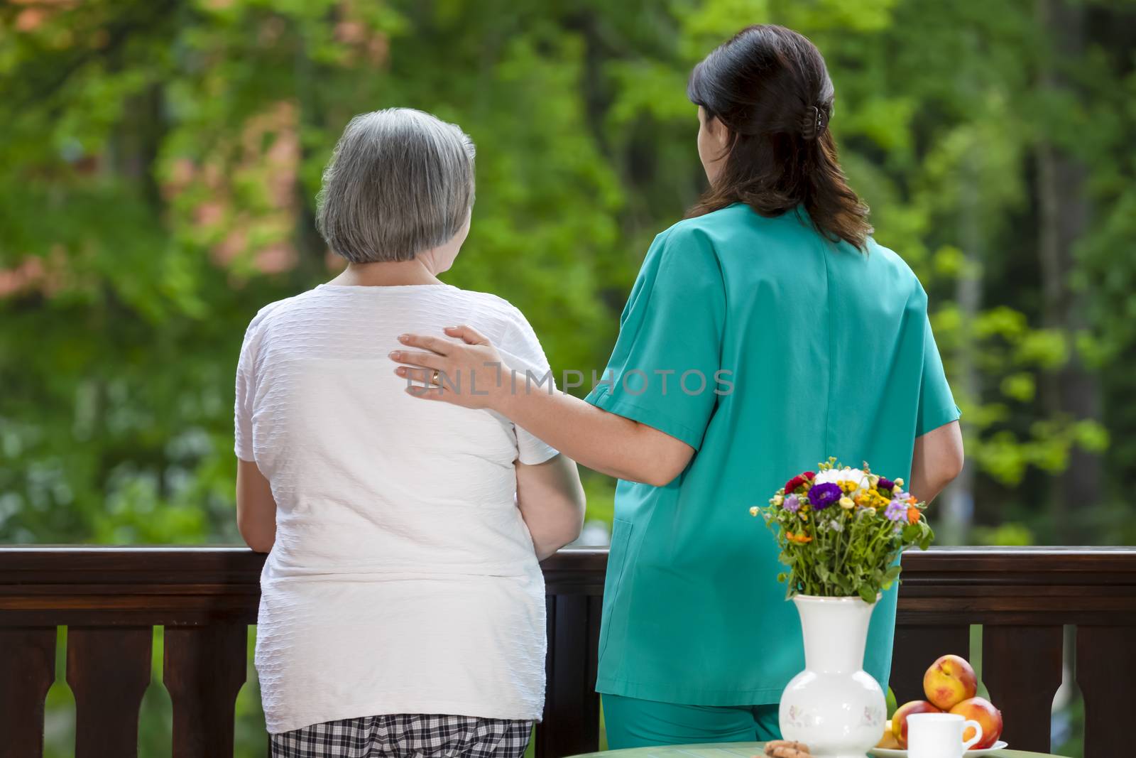 Elderly woman spending time with her assistance in nursing home care center.