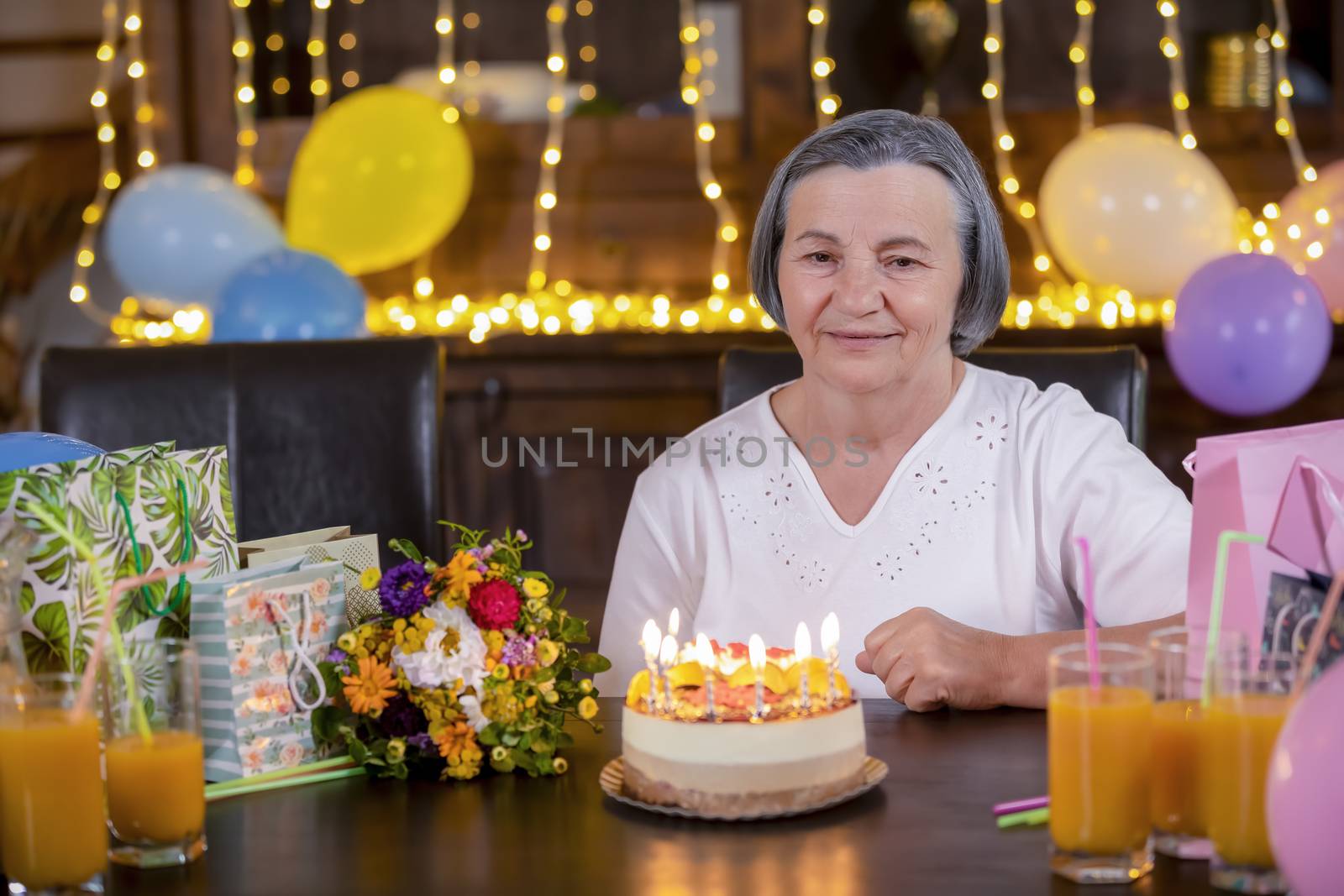 Senior woman with birthday cake at anniversary or Mothers Day pa by manaemedia