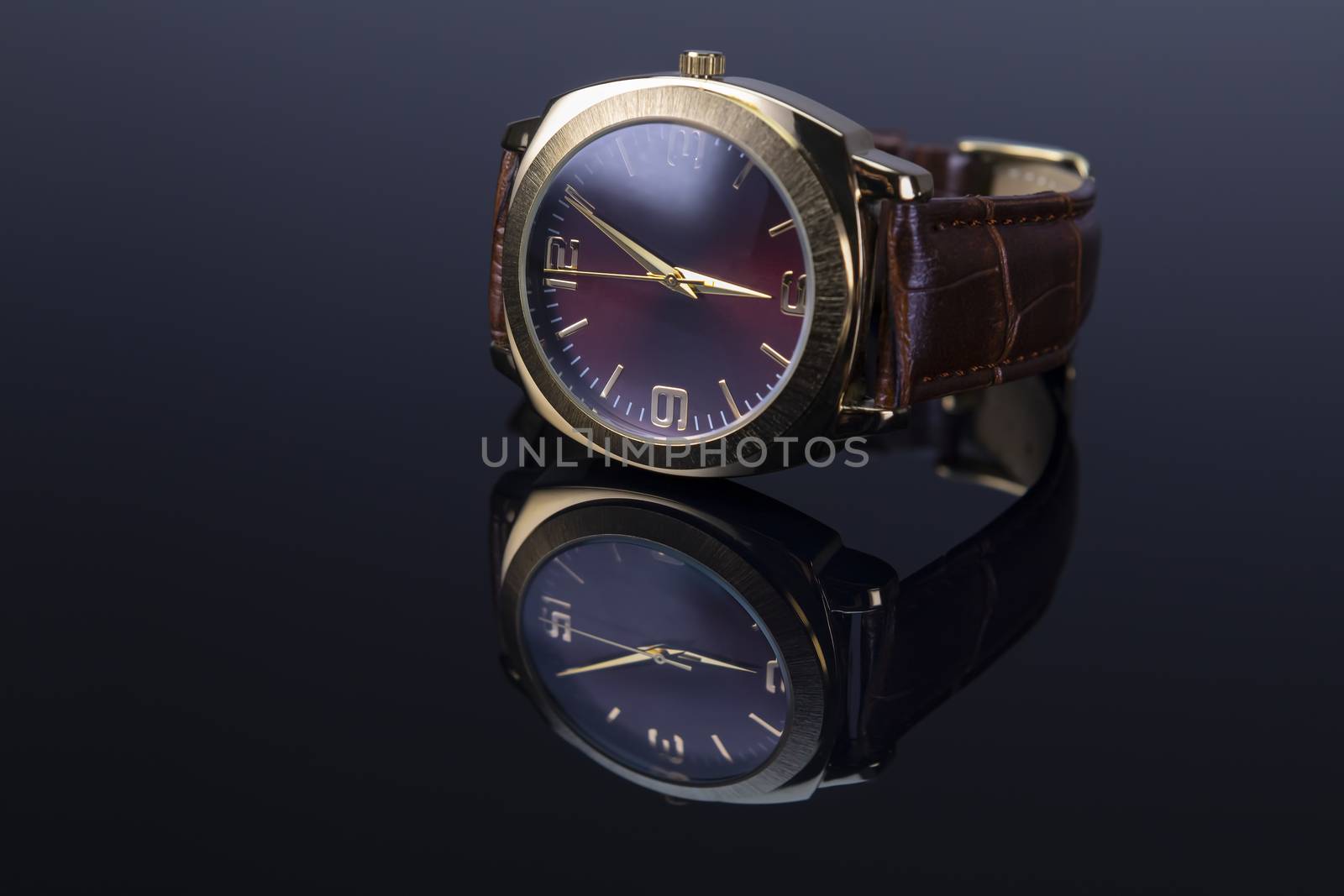 Men watch with leather bracelet on black glossy background. Focus on 9 a clock number.