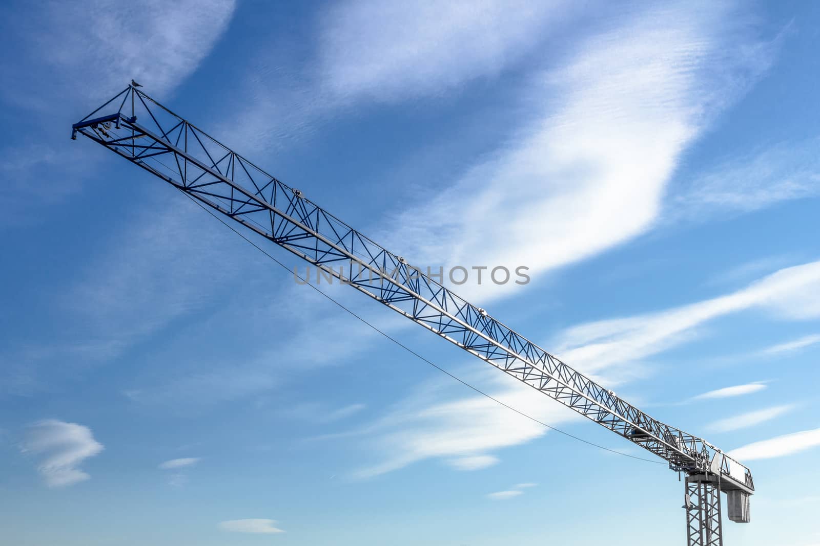 Bottom view of a large crane, with blue sky in the background.