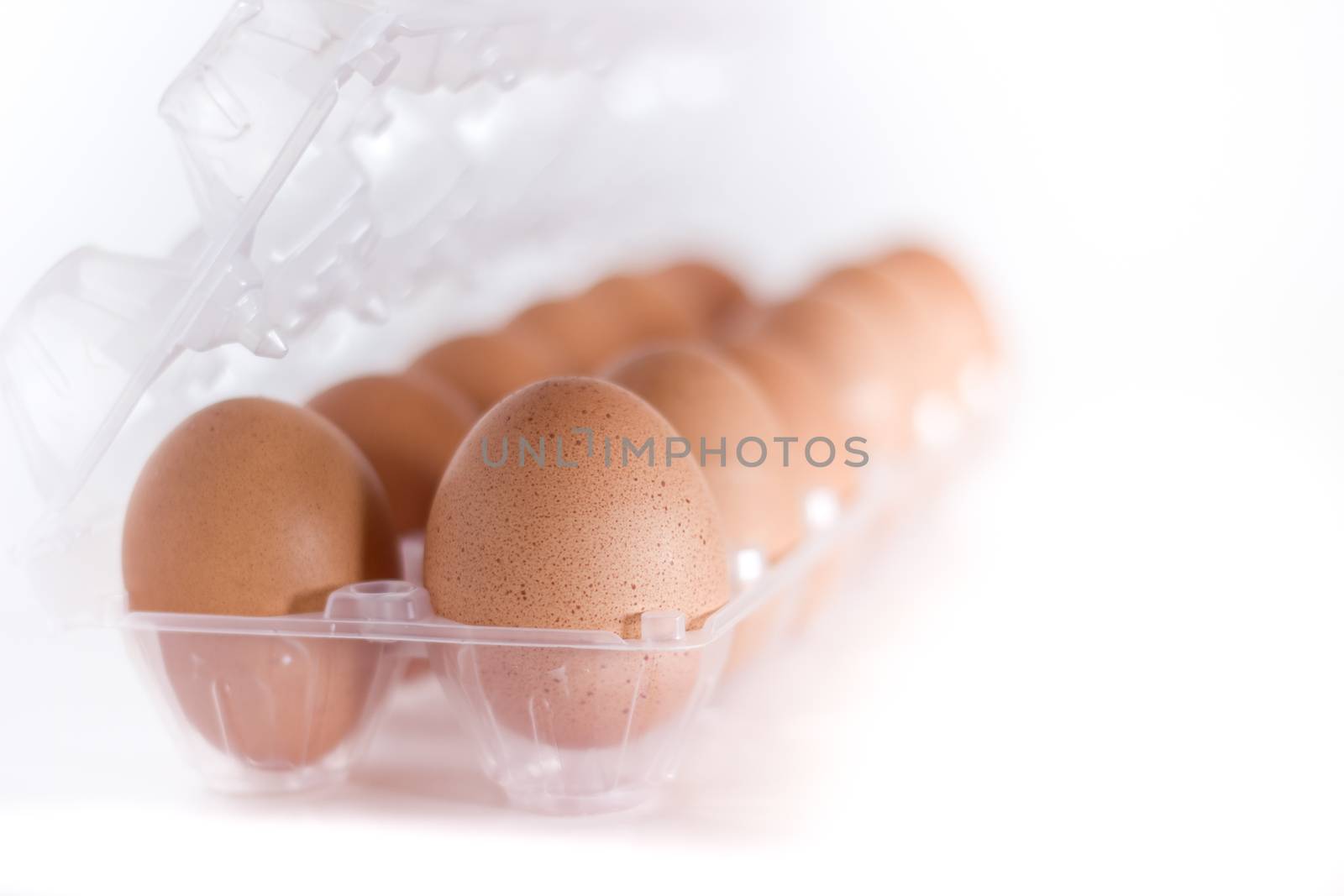 Container for eggs in clear plastic, isolated on a white background.